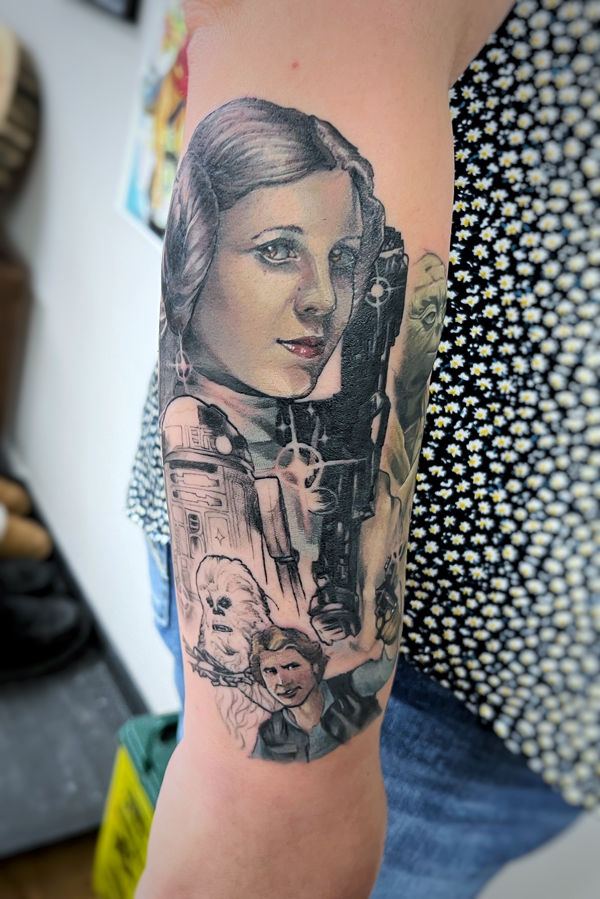 Tattoo of sci-fi characters and robots on a person's arm.