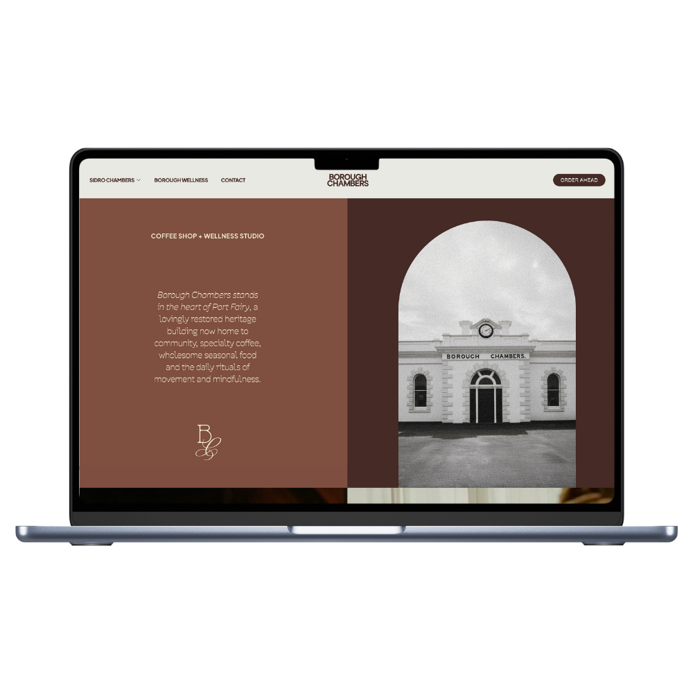 A laptop showcasing a website for Borough Chambers, featuring a photo of a historic building and a description of a coffee shop and wellness studio inside.