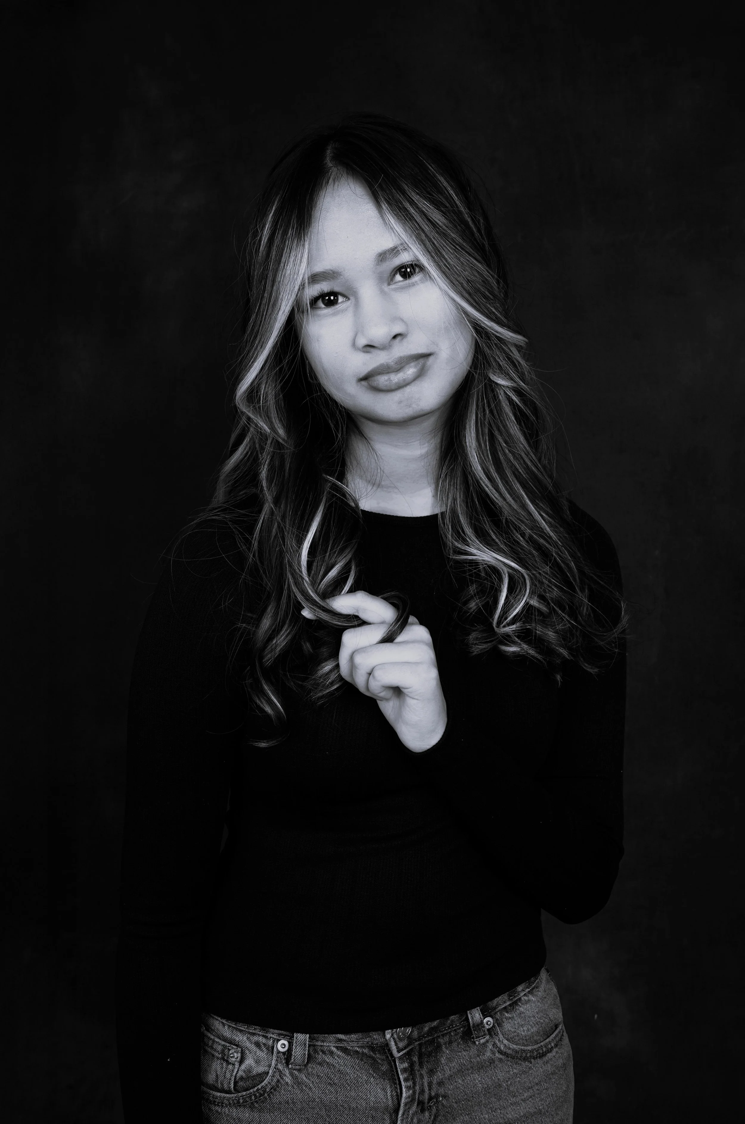 A woman's kids casting photo taken in a Raleigh photography studio for modeling and acting portfolios in black and white against a black background.