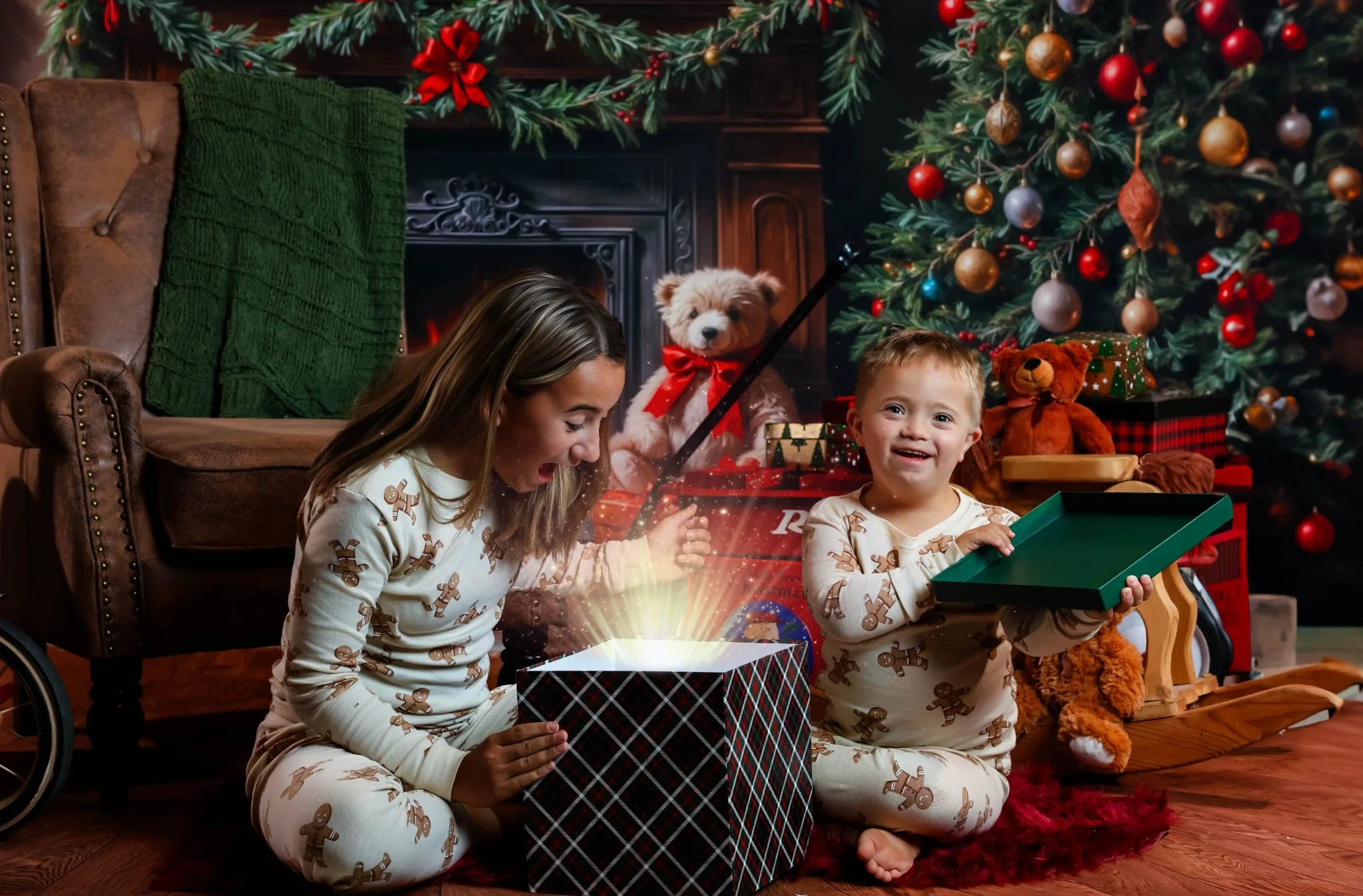 Two children in gingerbread pajamas discover a glowing present on a cozy Christmas set with fireplace and tree