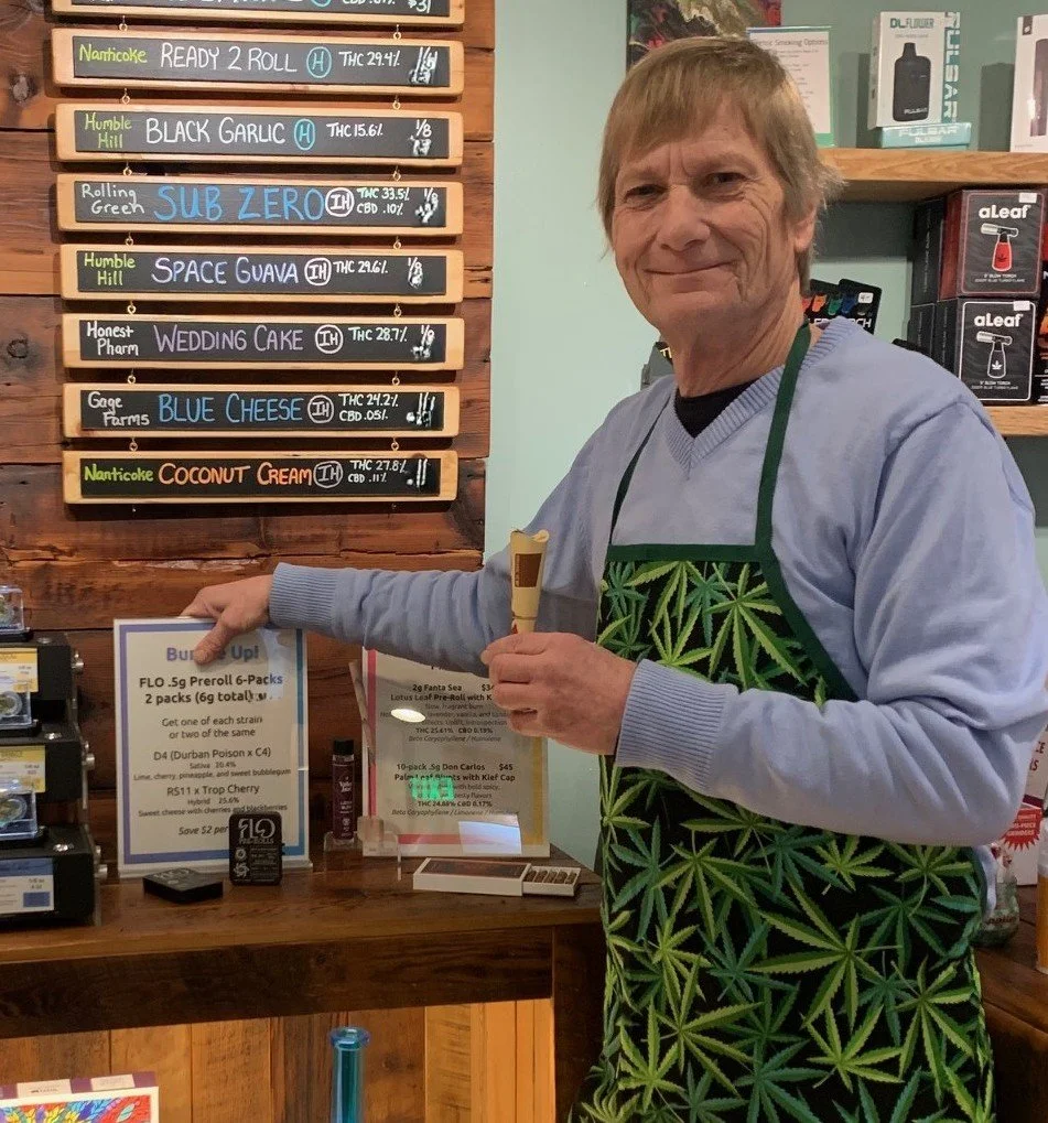 Team member Scott dressed in a cannabis apron in The Corner House shop