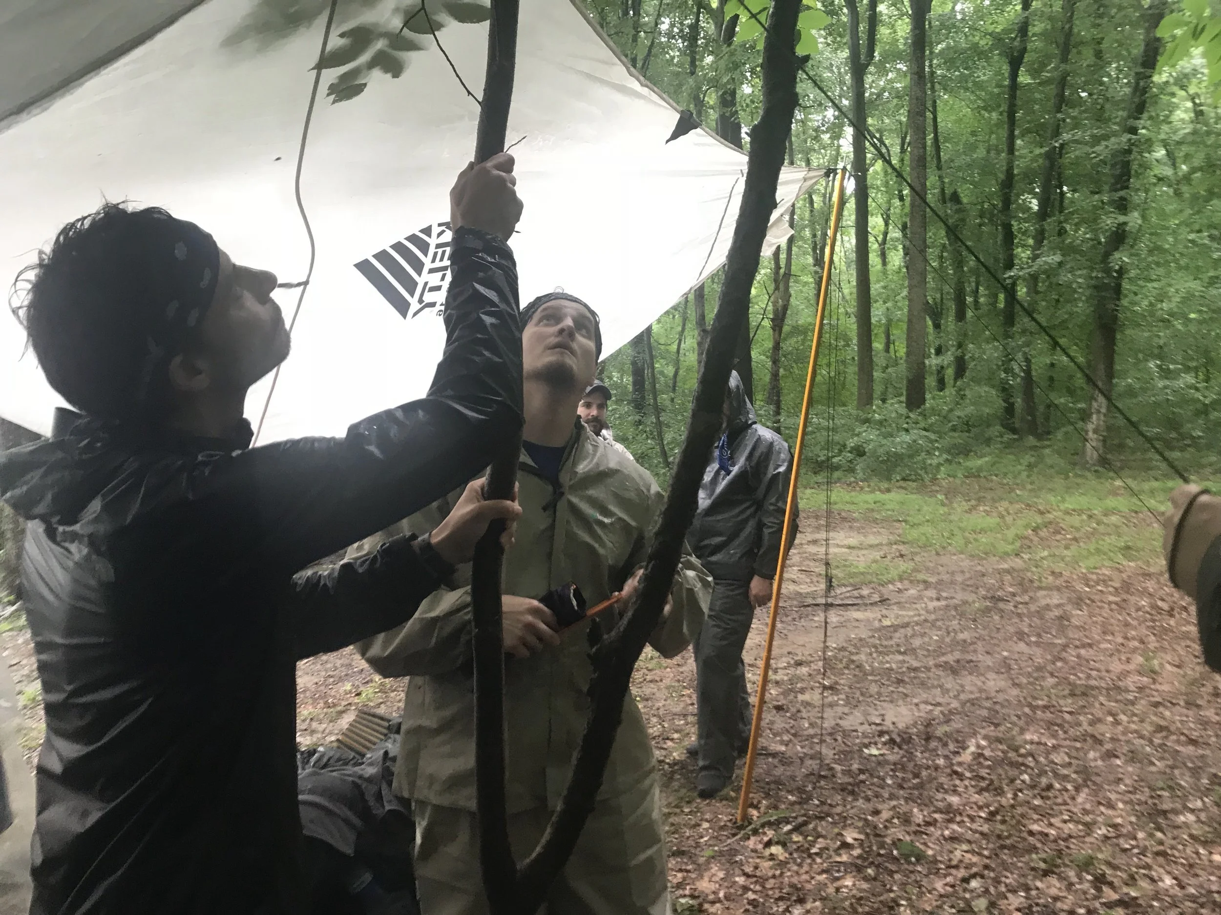 Levi and other participants from 2018’s Executive Summit Wilderness Excursion crafting a rain shelter.