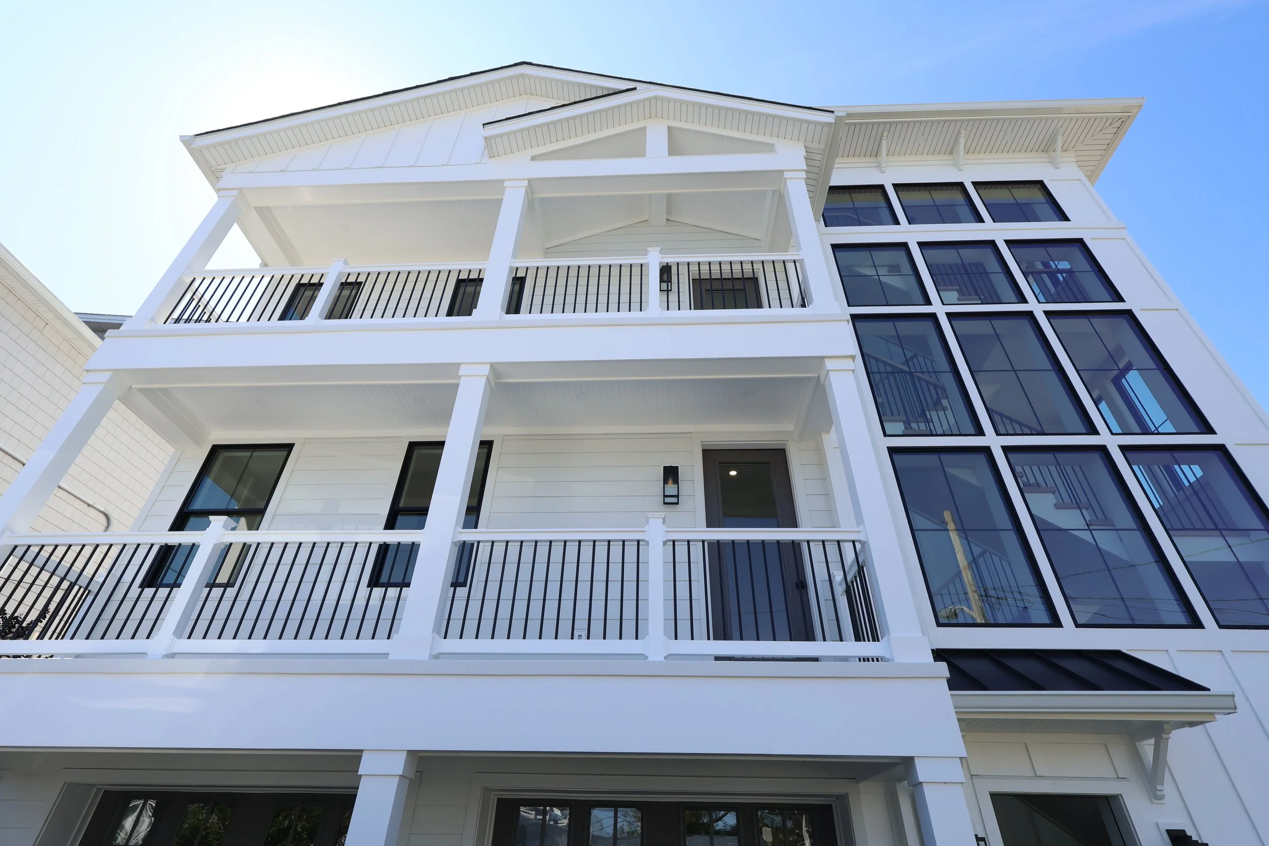 Modern white multi-story home with large windows showcasing James Hardie siding installed in Point Pleasant Beach, NJ.