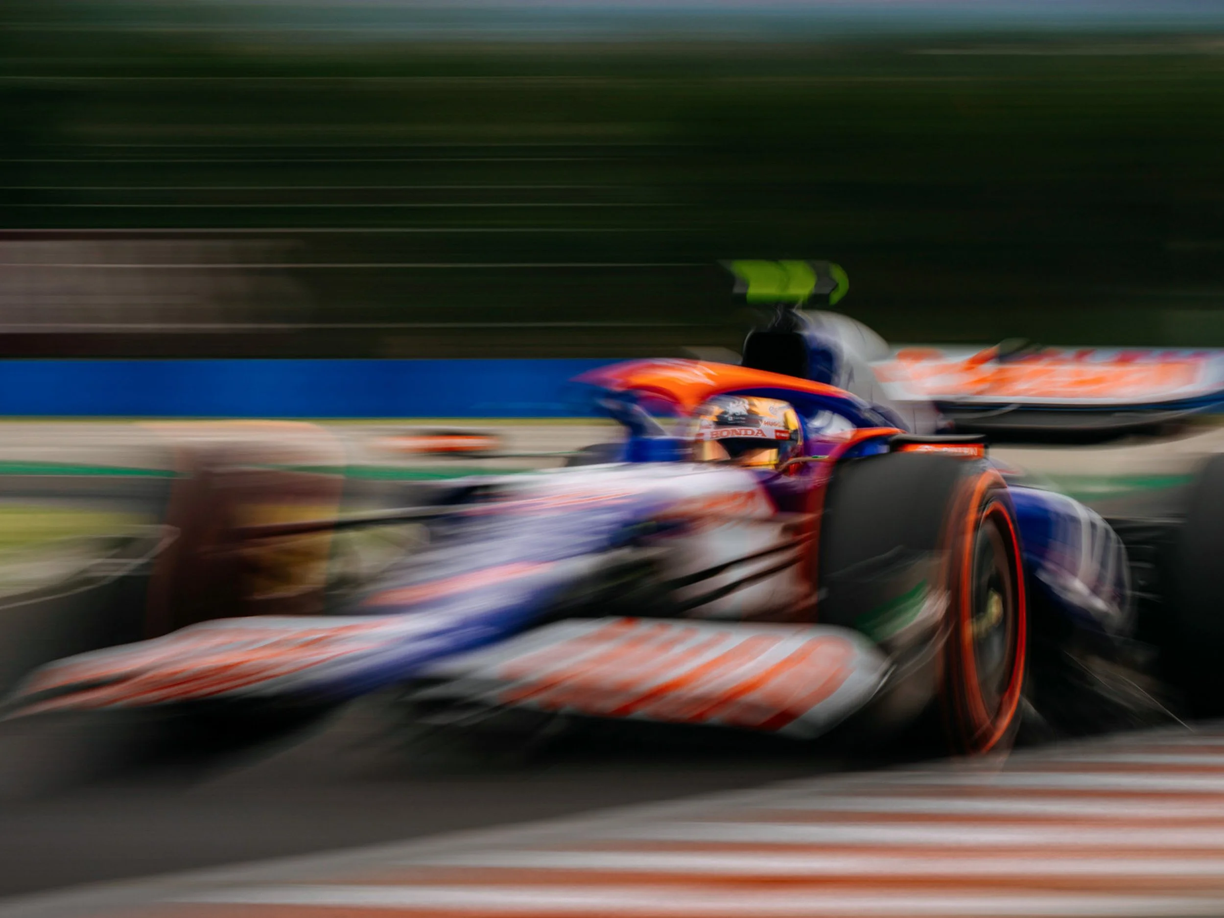 Motion-blurred Red Bull Racing Formula 1 car speeding around a racetrack