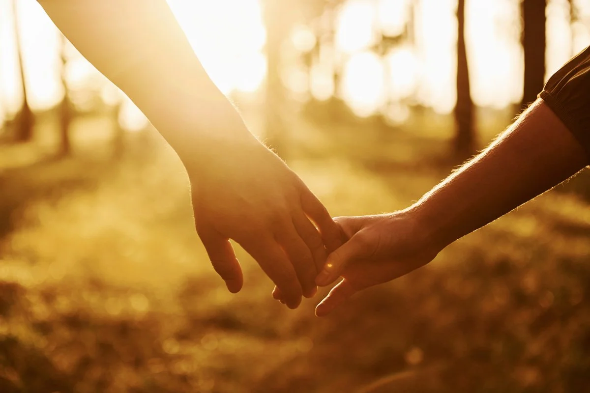 couple holding hands with backlight from the sun