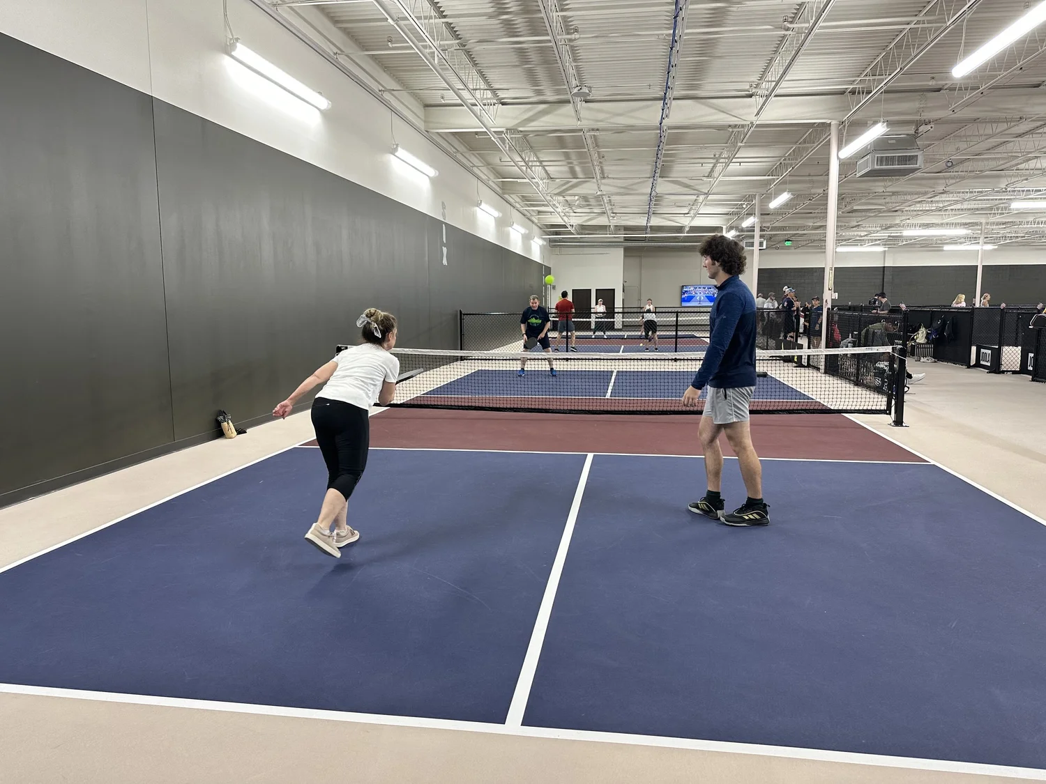 Players in a doubles game on Club 65's indoor courts