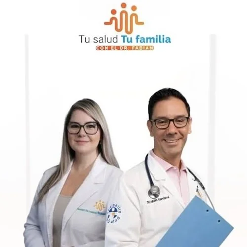 Two healthcare professionals, a woman and a man, wearing white lab coats and glasses, standing side by side against a plain white background. The woman has long blonde hair, and the man has short dark hair and is holding a blue clipboard. Above them is a logo and text in Spanish.