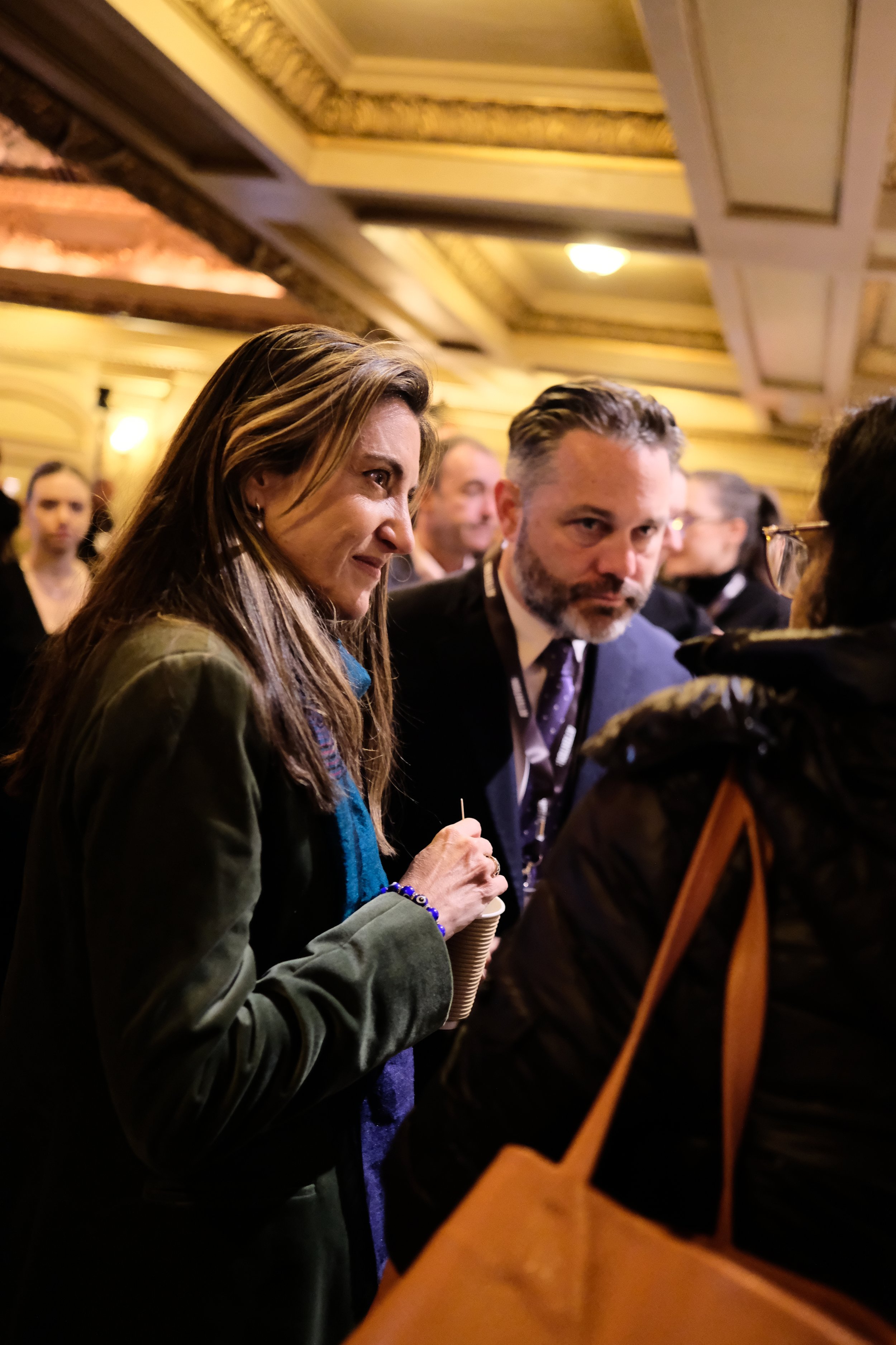 Patricia Campos Mello and Justin Hendrix lean in as they discuss with fellow conference attendee.