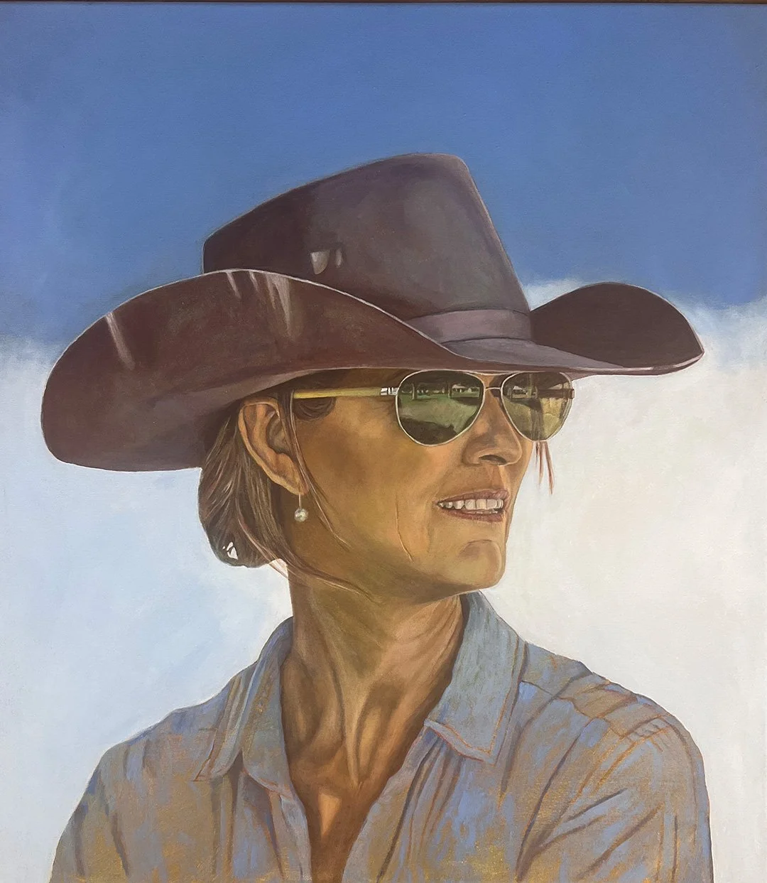 A painted portrait of a woman wearing a wide-brimmed brown hat, aviator sunglasses reflecting greenery, and a light denim shirt, standing against a cloudy sky background.