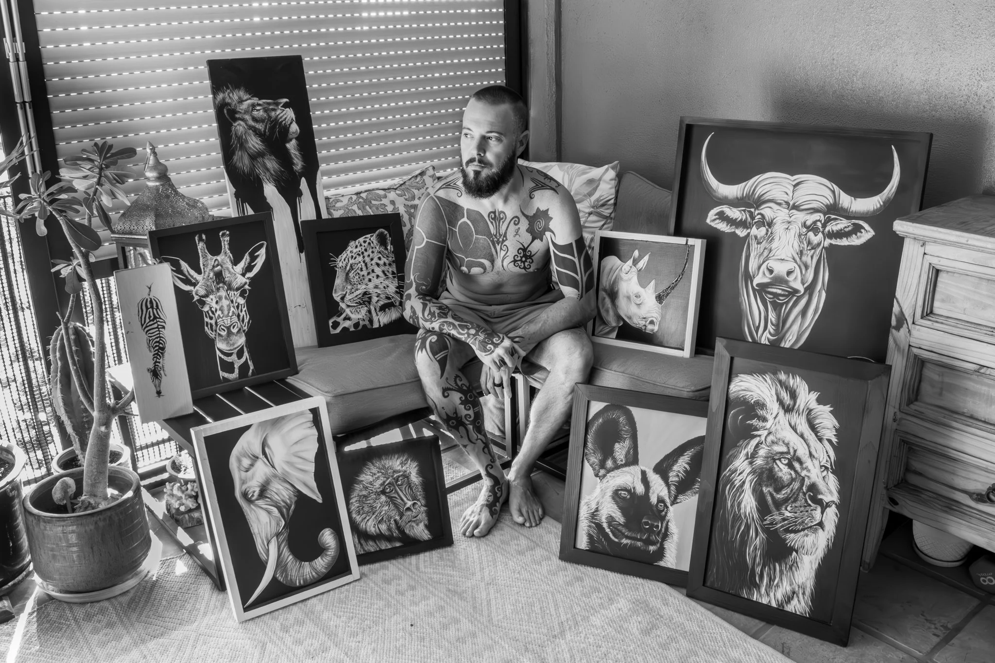 Nate Doucette, fine art painter, in his Honolulu studio with African and North American wildlife paintings