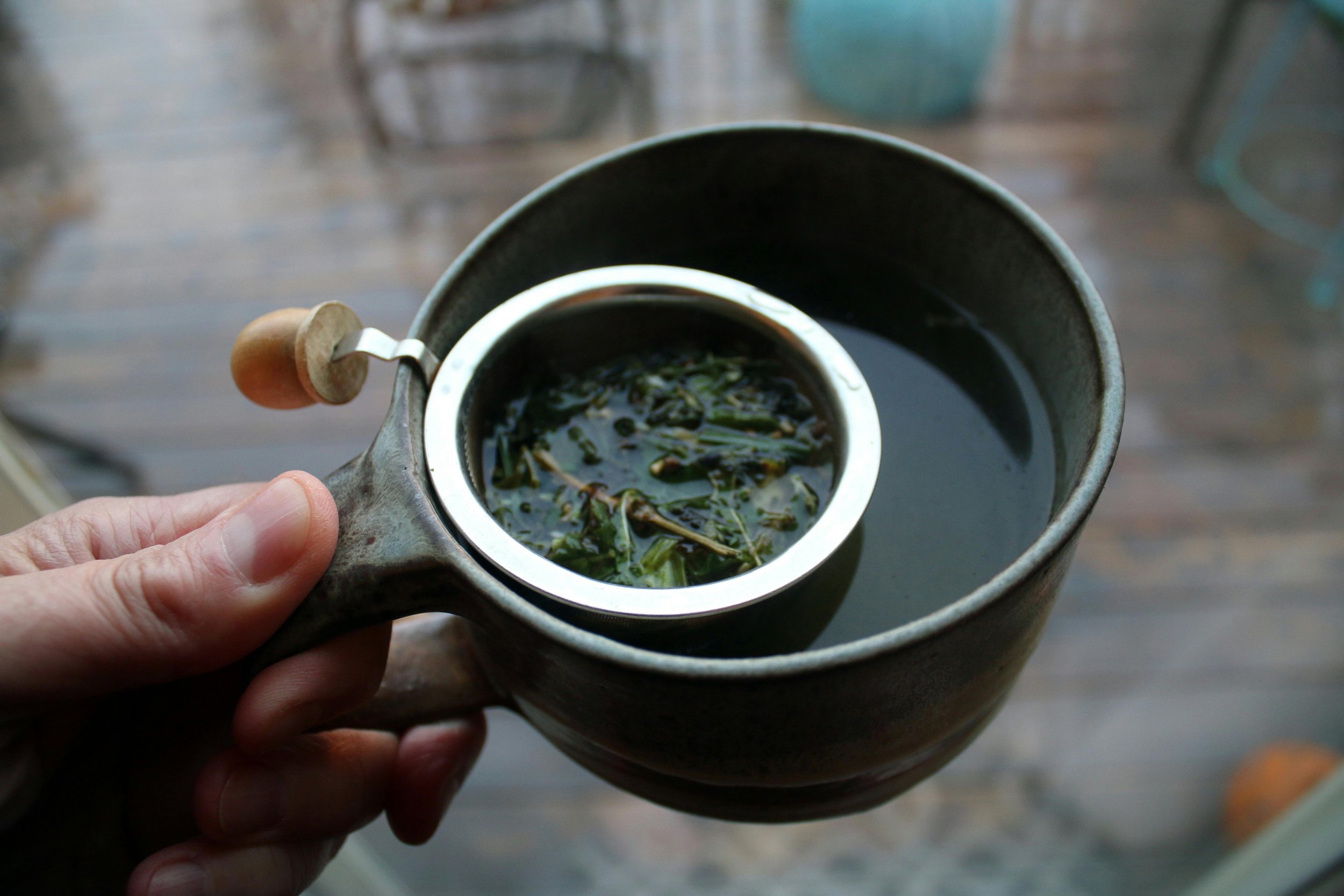 A cup of tea filled with organic herbs for healing.