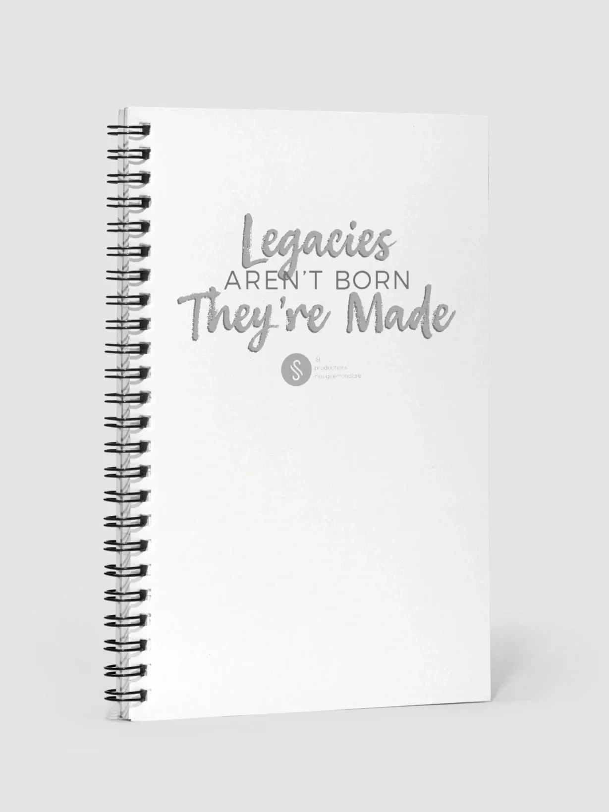 White spiral notebook with the quote "Legacies aren’t born, they’re made" on the cover.