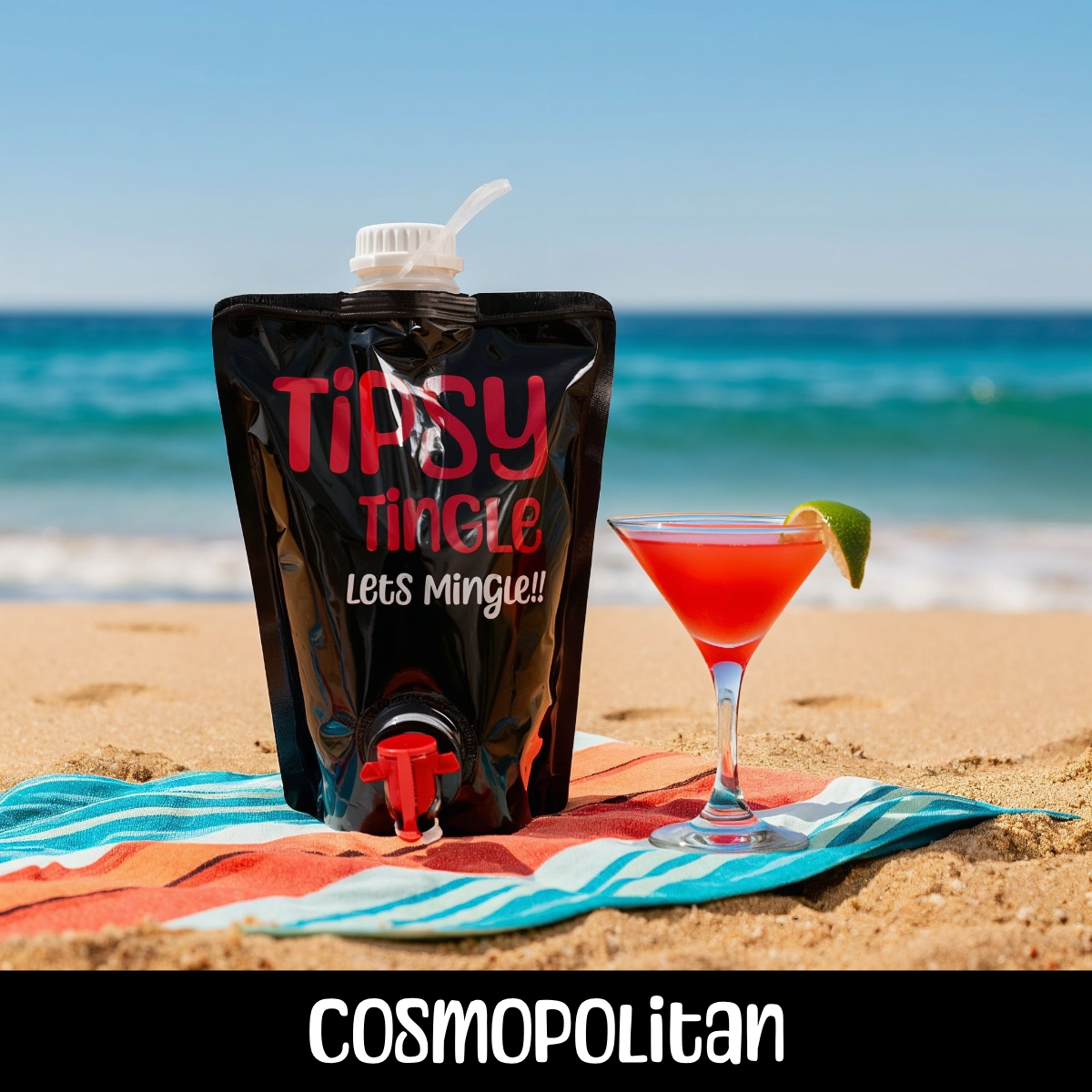 A red cocktail with a lime wedge on a beach towel, next to a black pouch labeled 'Tipsy Tingle Lets Mingle' with a spout, on a sandy beach with the ocean in the background.