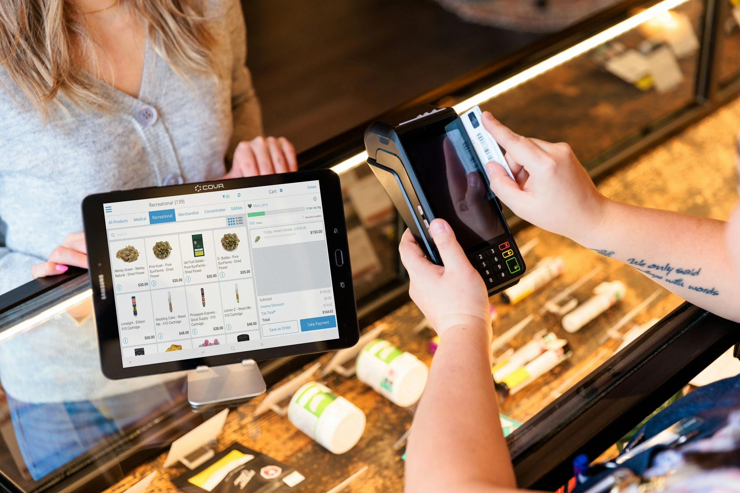 Customer completing a purchase transaction using a payment terminal and digital point-of-sale system, illustrating how customer journey analytics connects interactions across channels to improve marketing performance.