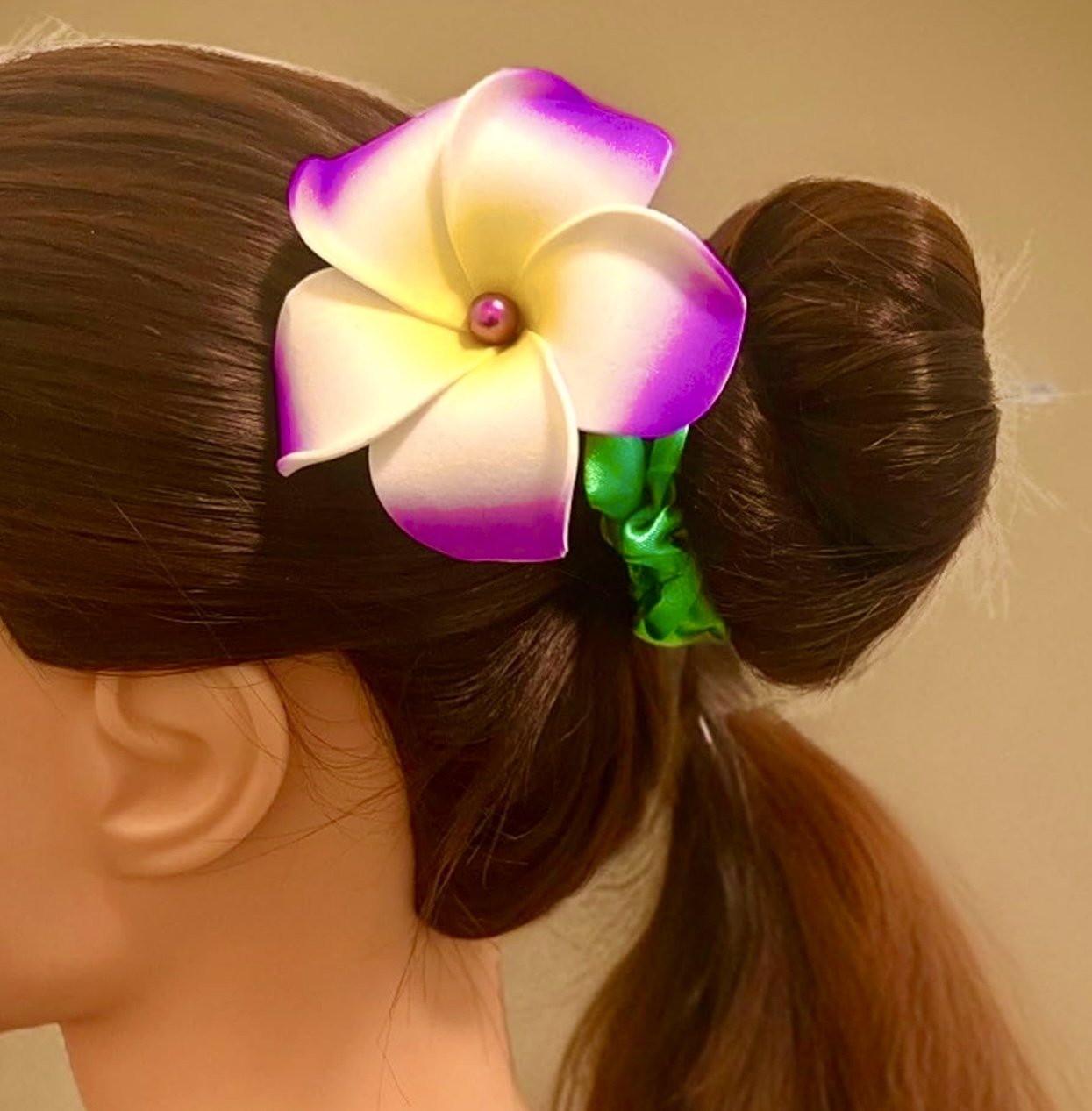 Woman wearing purple foam plumeria flower on her hair
