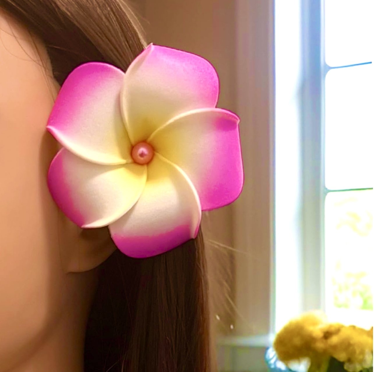 Woman wearing pink foam plumeria flower on her hair
