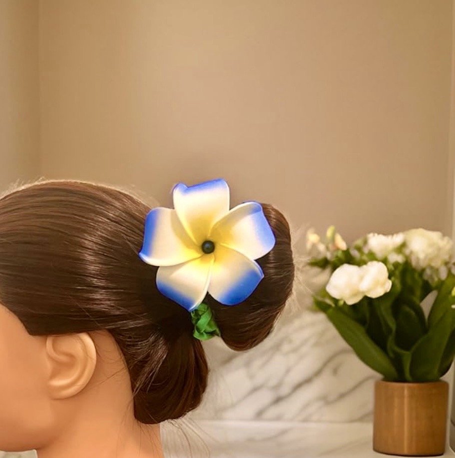 Woman wearing blue foam plumeria flower on her hair