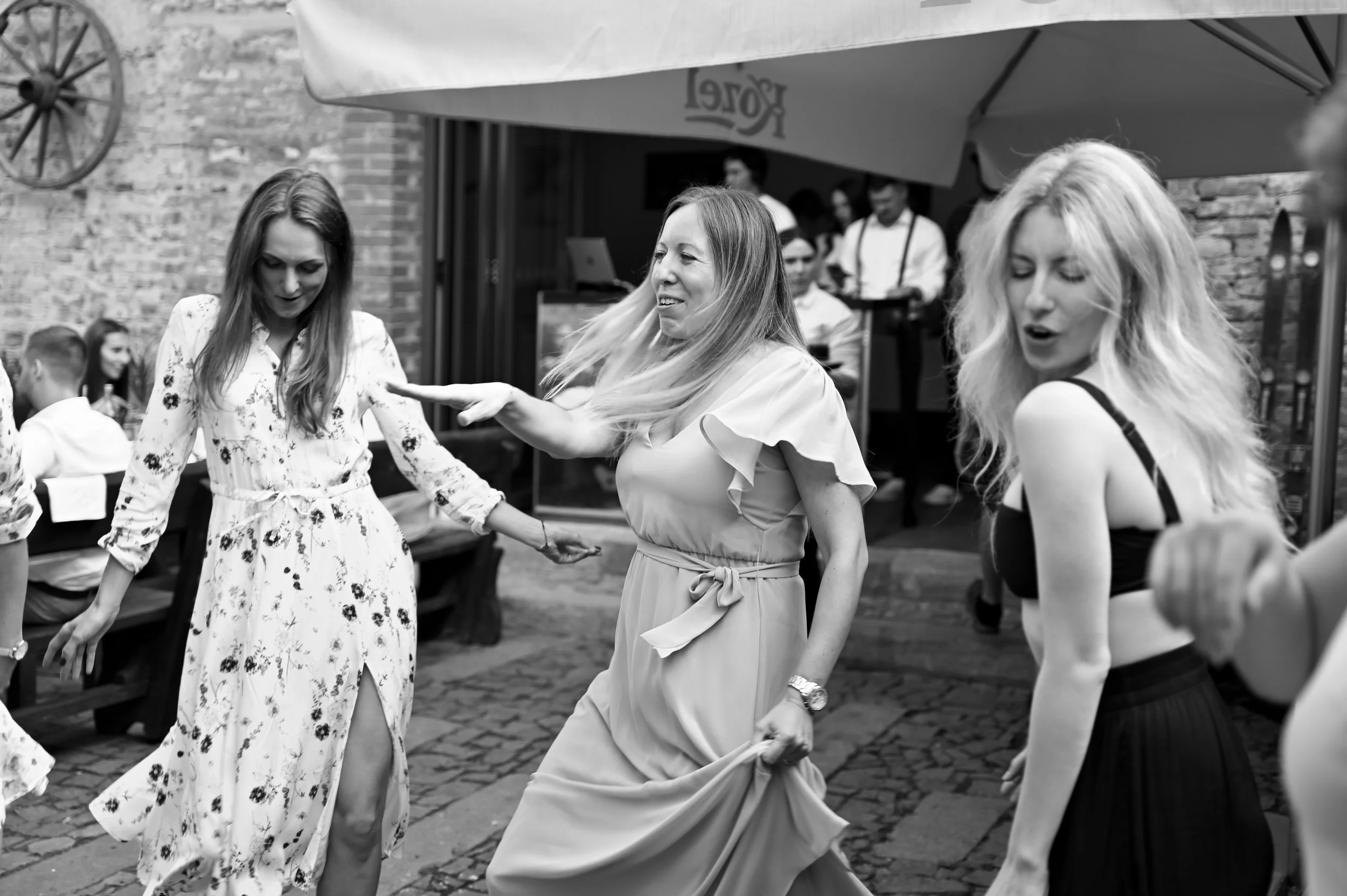 Women dancing and having fun at an outdoor gathering or party.