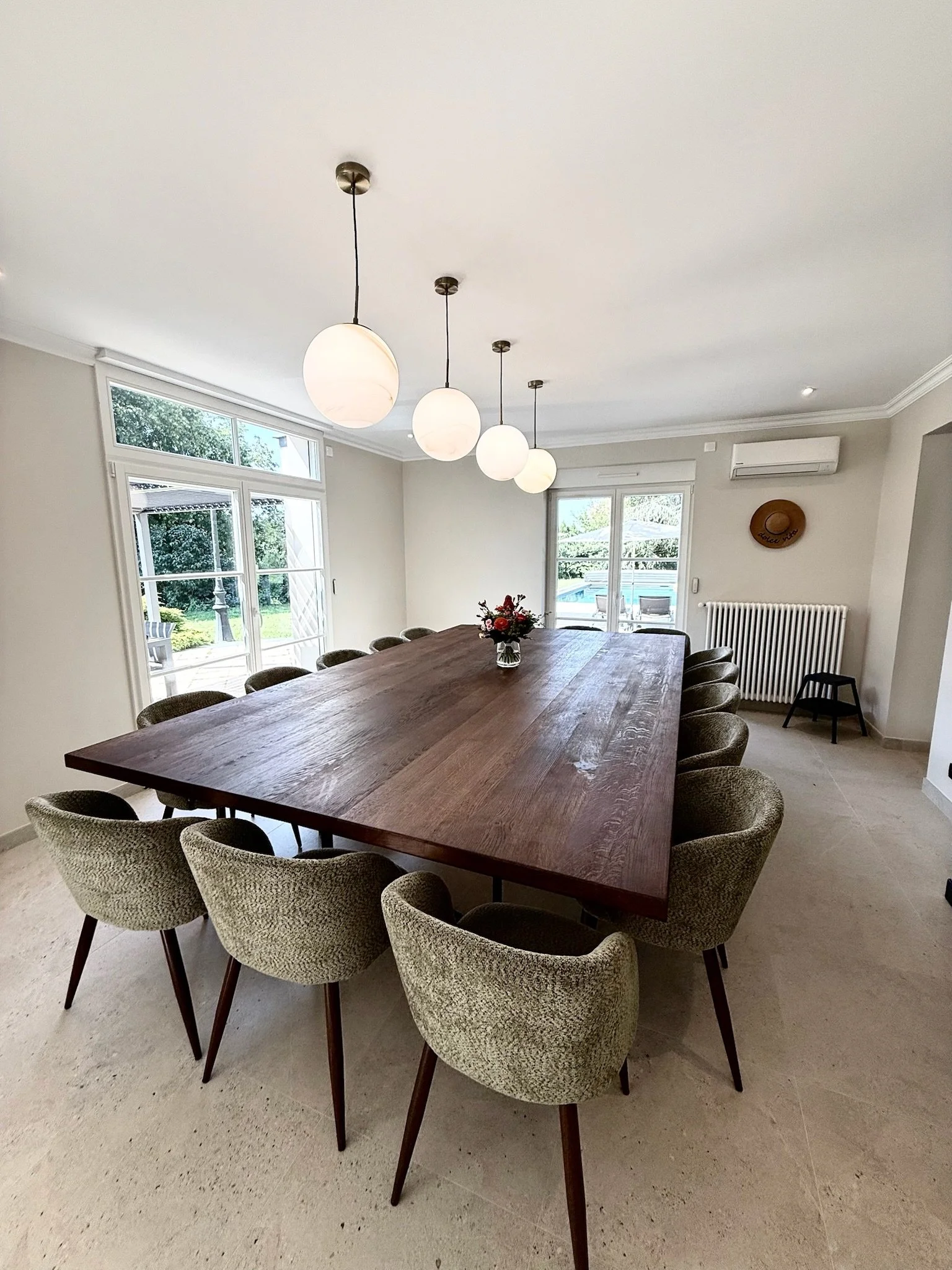 Salle à manger avec une grande table pour 15 personnes et des chaises dans le grand gîte près d'Angers