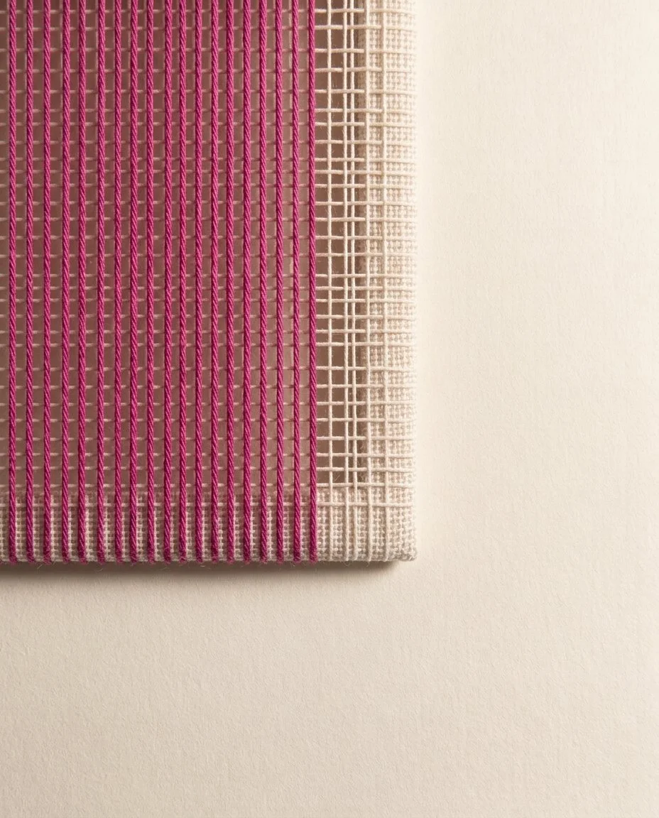 Many magenta threads running in ordered parallel through a neat pale grid, like an orderly section of loom.