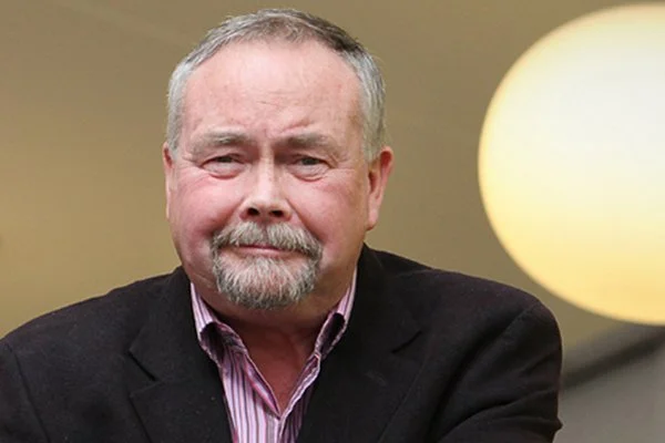 Frank Hennessy, in a dark blazer and striped shirt.
