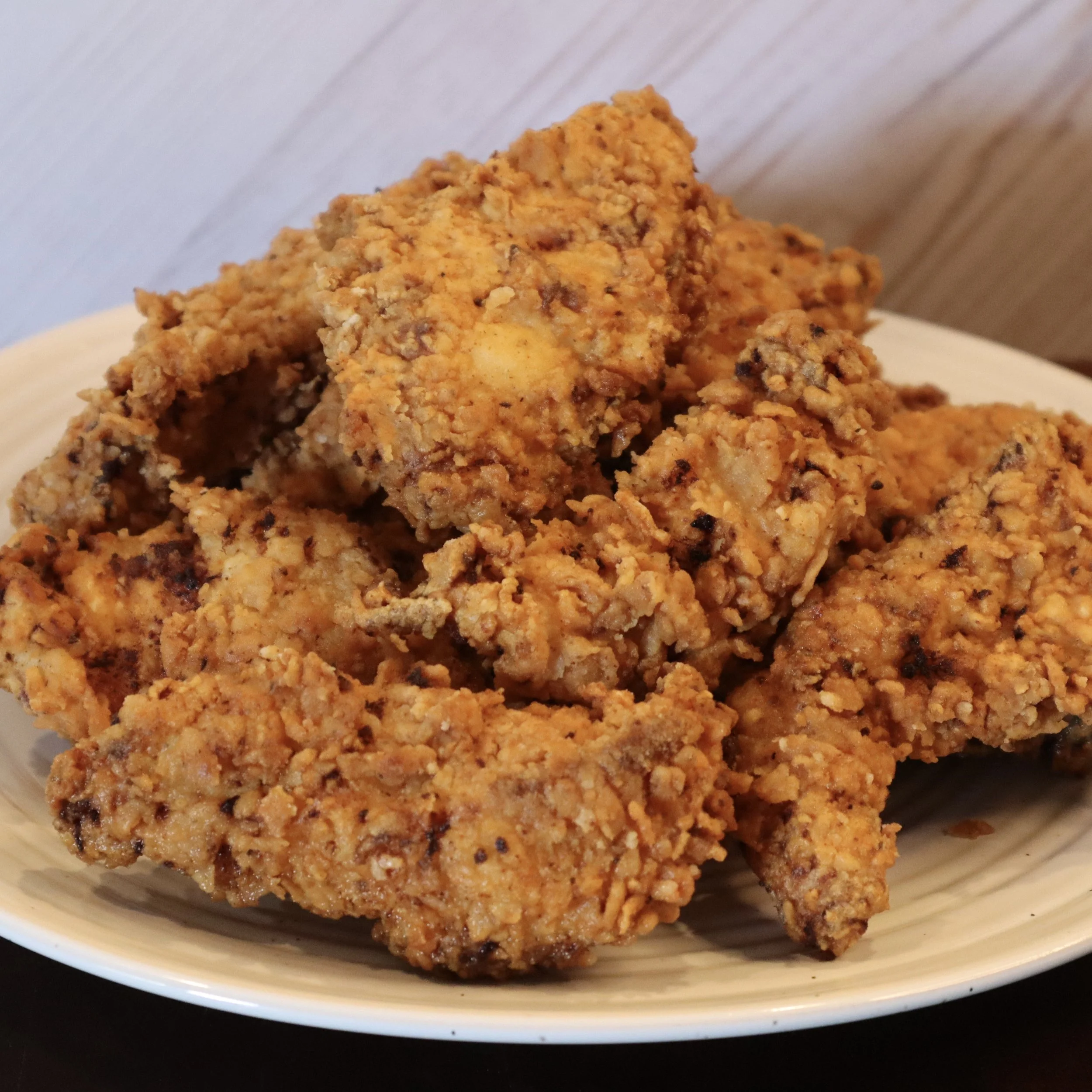 Close-up of a plate of crispy fried chicken pieces.