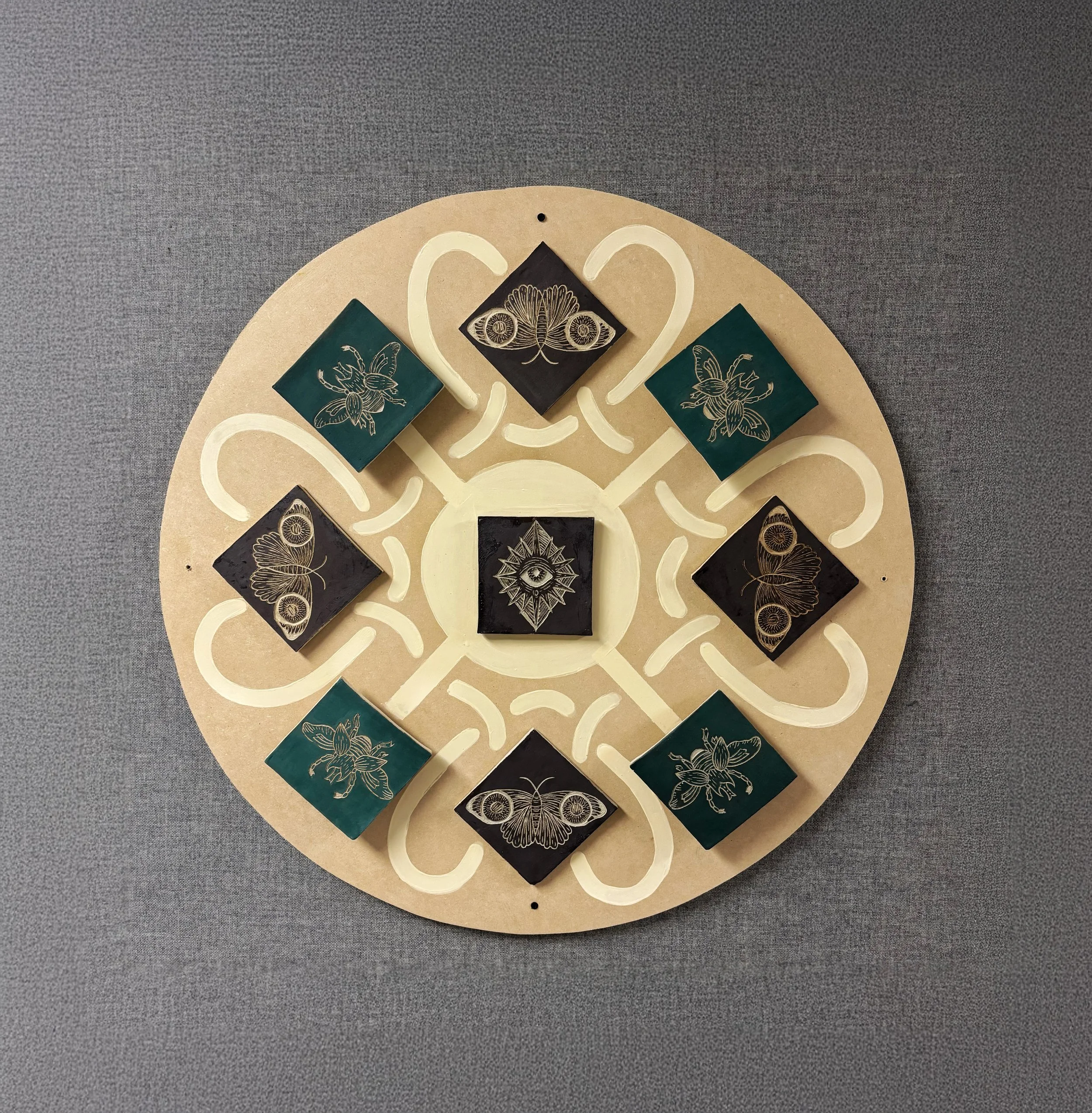 Inspired by Celtic knots and printmaking, I created a radial piece that communicates rebirth through the designs, carvings, and colors. (materials: clay, underglaze, wood)
