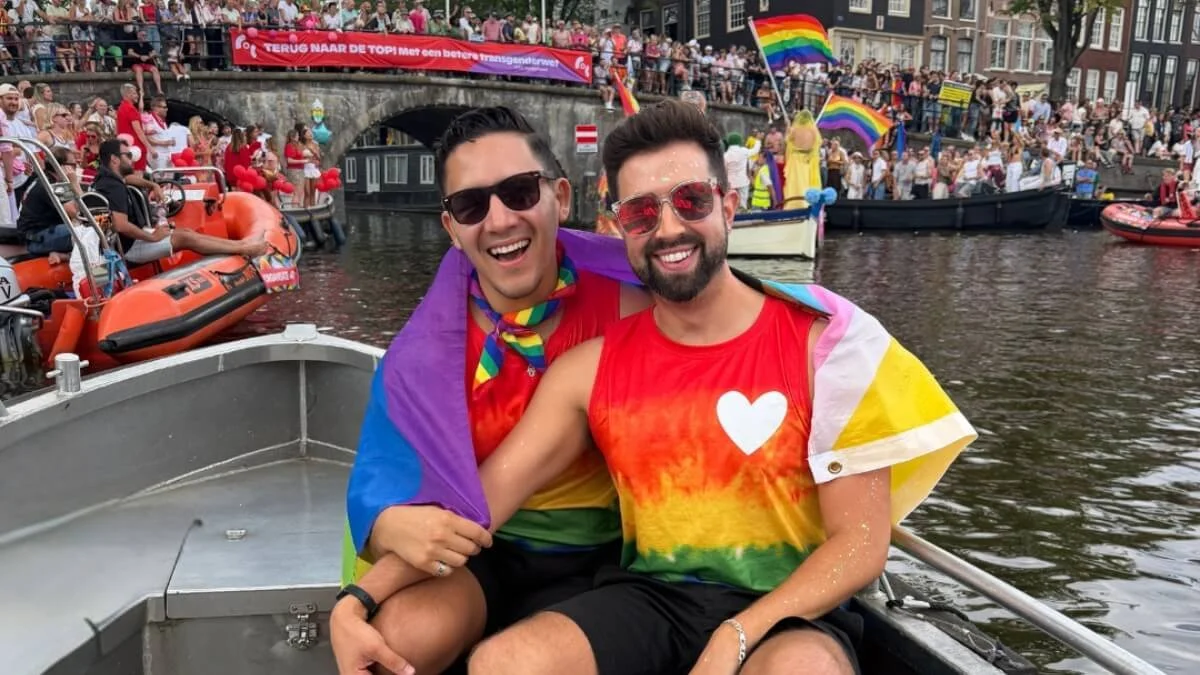 Gay couple celebrating at the Amsterdam Canal Parade during WorldPride 2026