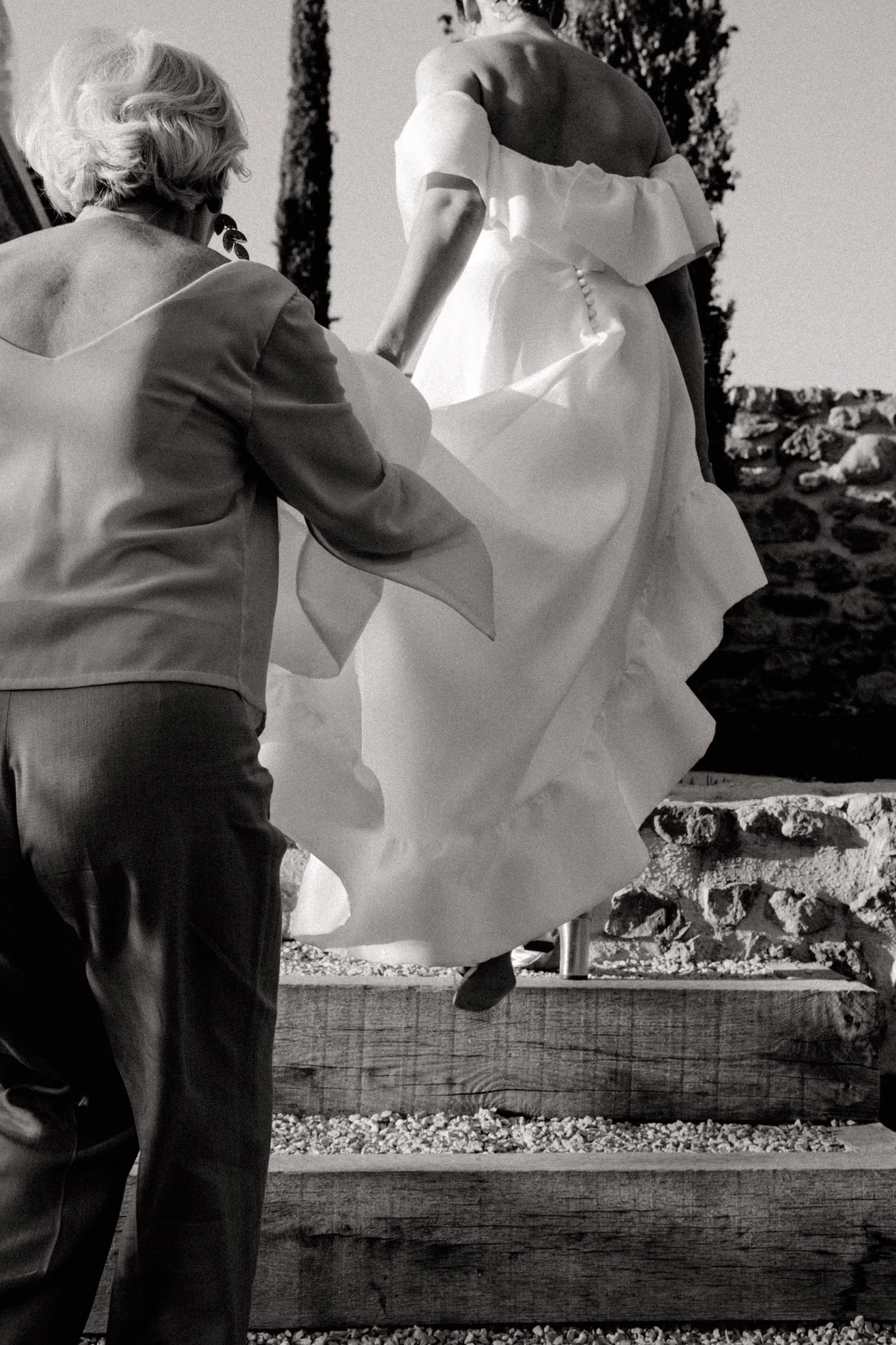 Une mère tient la traine de sa fille de sa robe de marié lors de la cérémonie