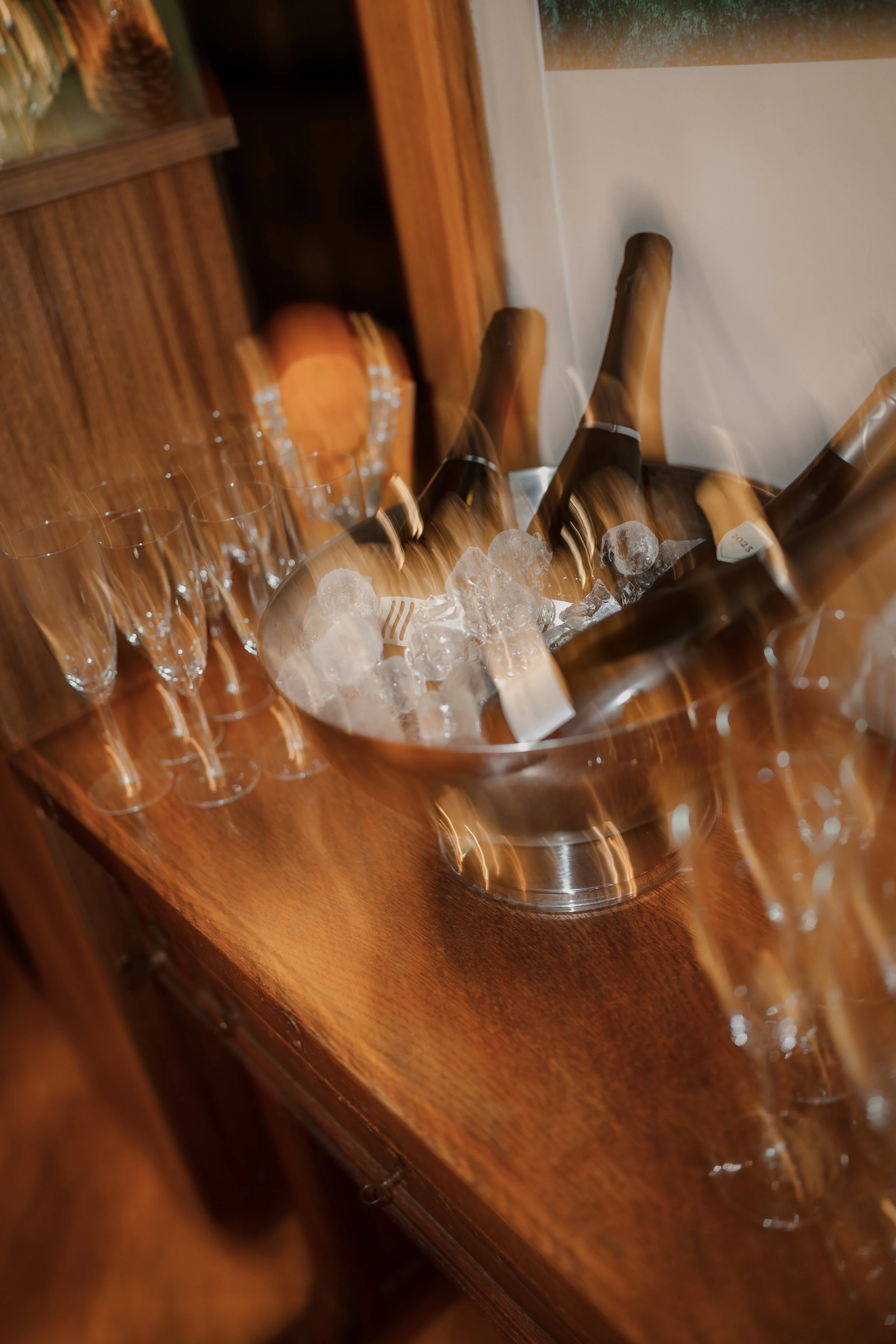 Bouteilles de champagne dans un seau à glace avec verres à champagne sur une table en bois.