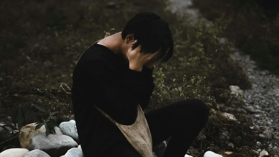 A stressed man with hands on face