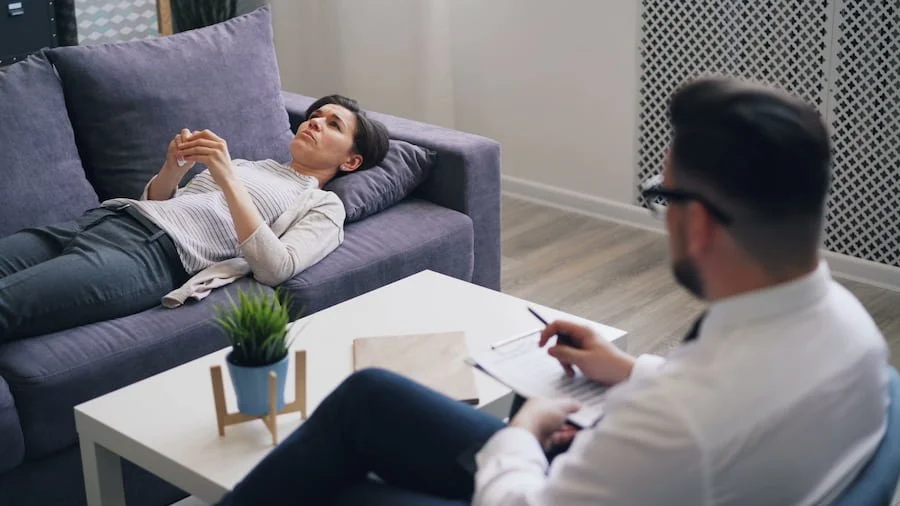 A woman engaged in a therapy session with a psychologist in a modern office setting.