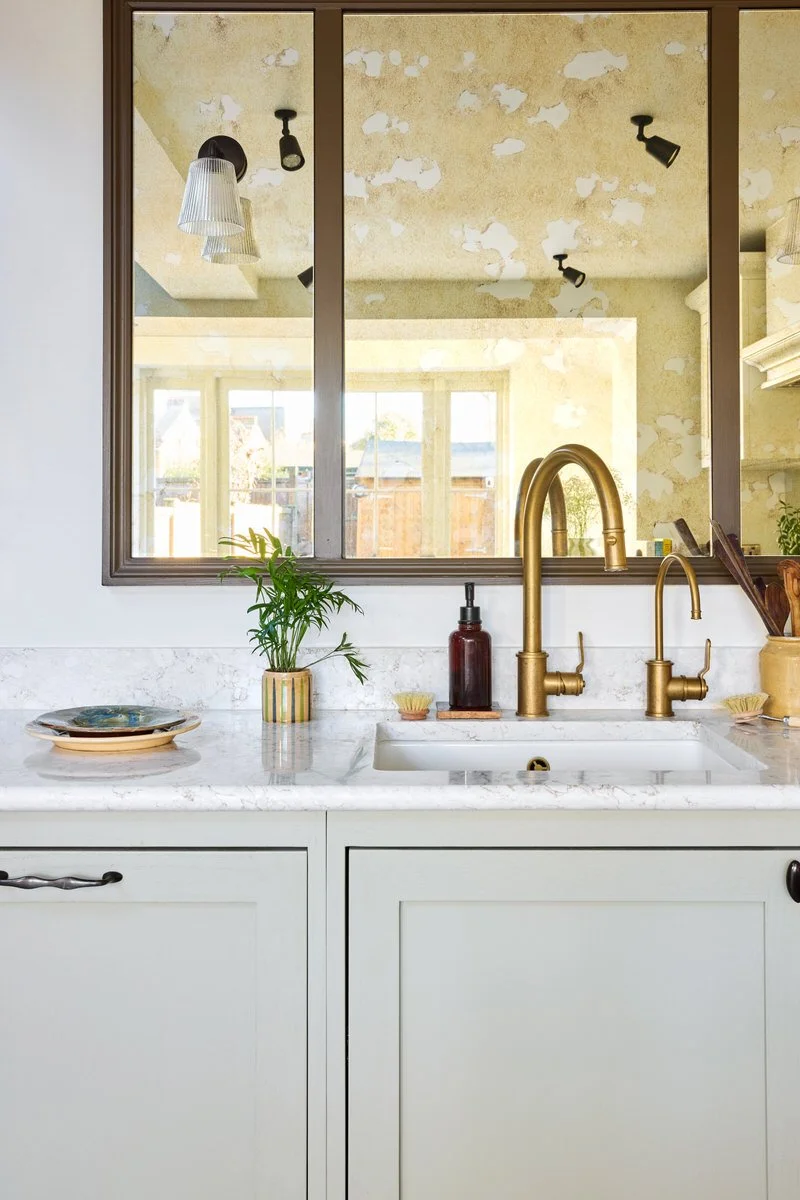 Luxury soft kitchen cabinetry in pale green and pink within a London kitchen extension