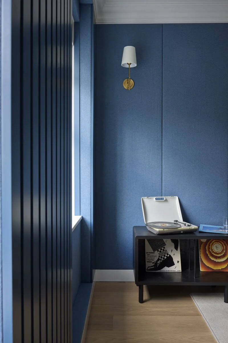 Record player and vinyl in blue music room with carefully constructed acoustic panelling
