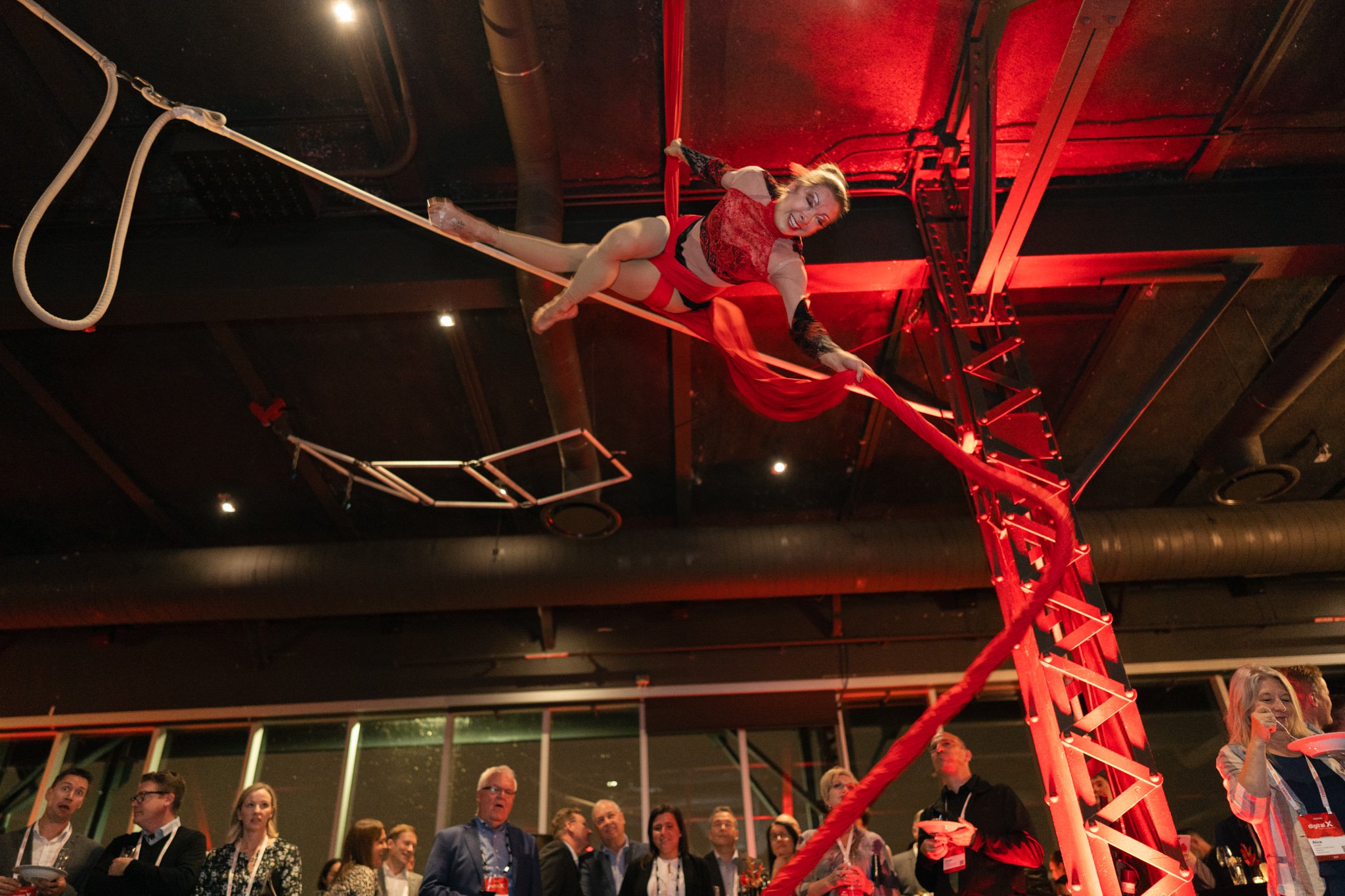 BMW event in Montreal with acrobats performing on a trapeze above a crowd of people watching captured by Squareloop.