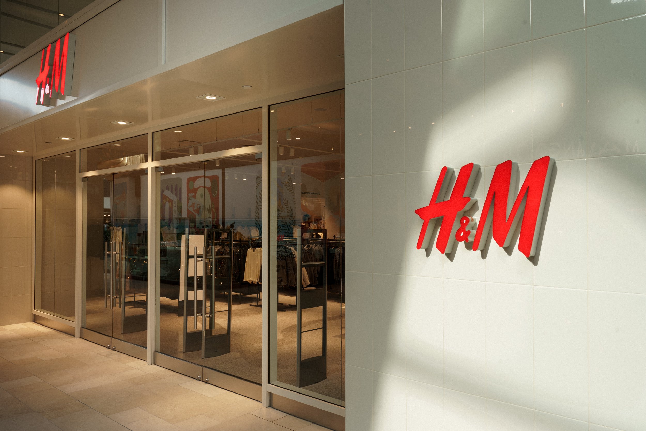 Exterior architectural photograph of the H&M store at Royalmount Montreal, showcasing modern retail facade design, photographed by SquareLoop.