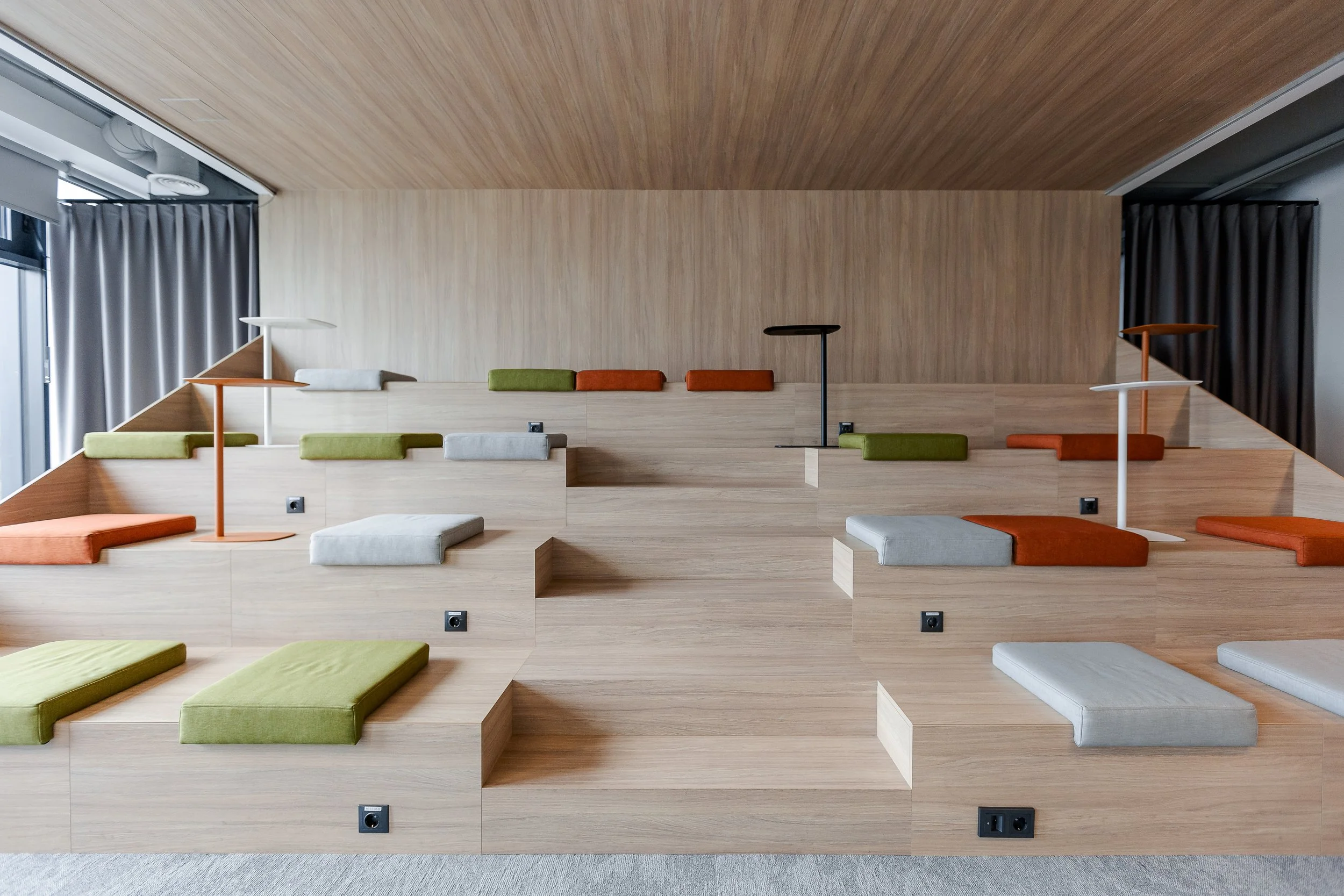 office interior furniture with wooden amphitheater with soft fabric pillows