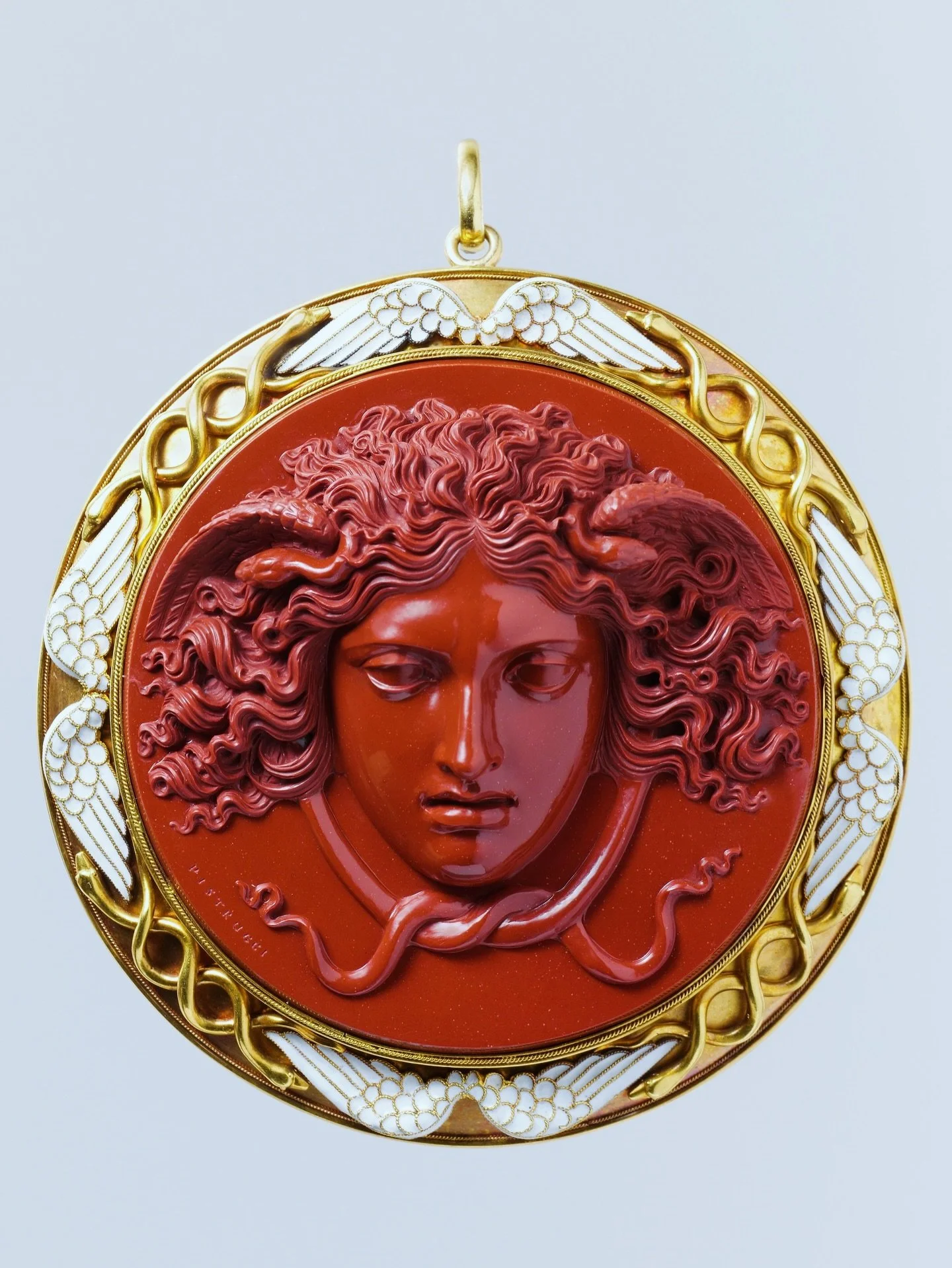 Red jasper head of Medusa cameo engraved by Benedetto Pistrucci and mounted in a gold and white enamel winged pendant frame by Carlo Giuliano, circa 1860. From the @metmuseum collection #cameo #redjasper #fabulousjewels