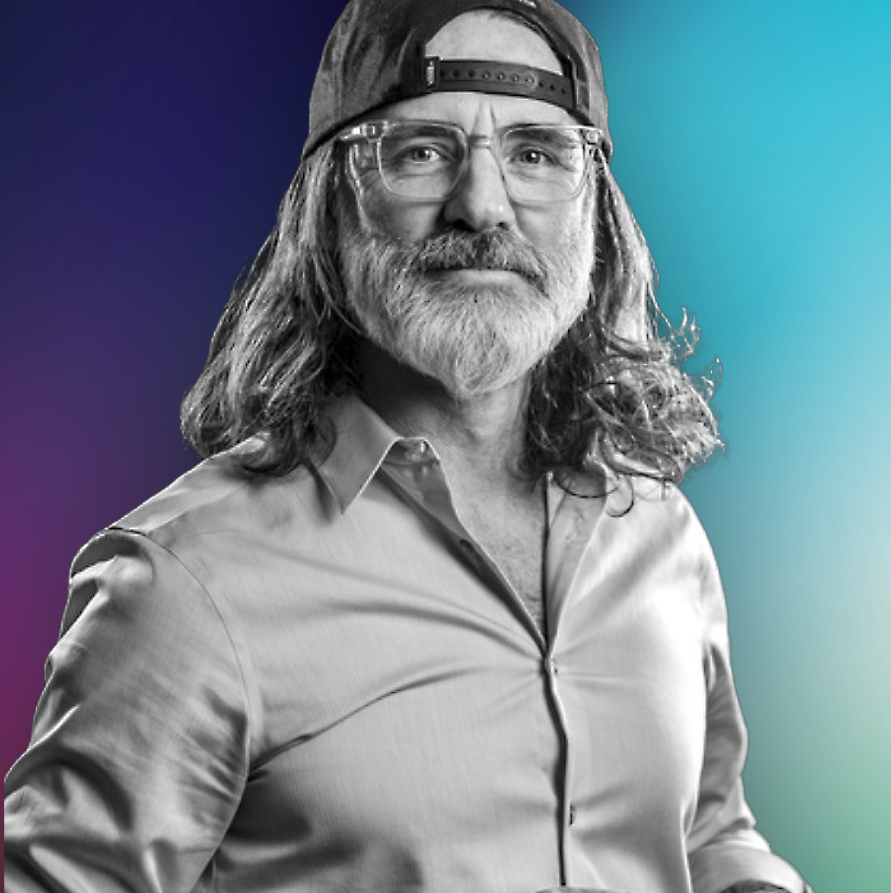 A man with long hair, gray beard, wearing glasses, a backward baseball cap, and a button-up shirt, standing against a background with a gradient from purple to teal.