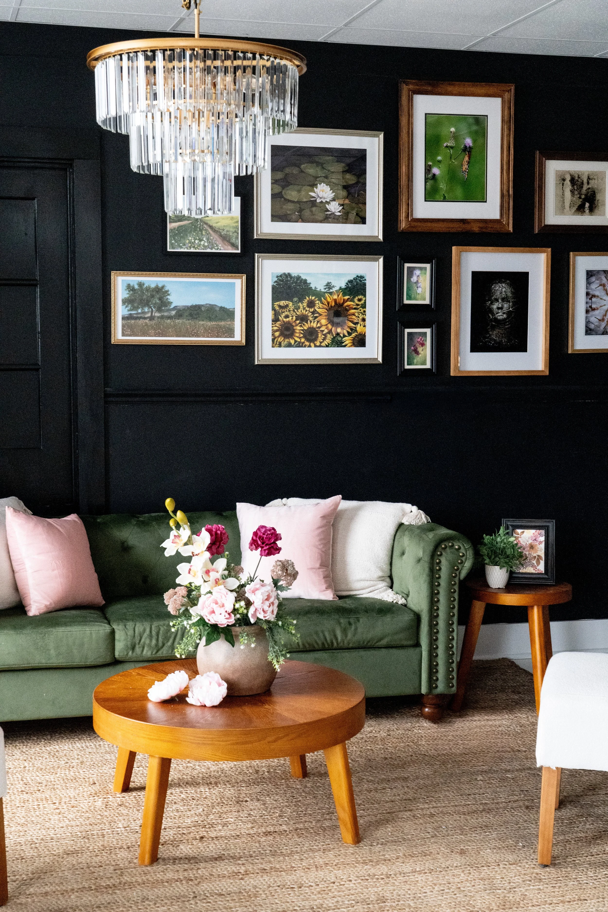 Spring Couch using pinks and whites with framed galelry wall and elegant chandelier
