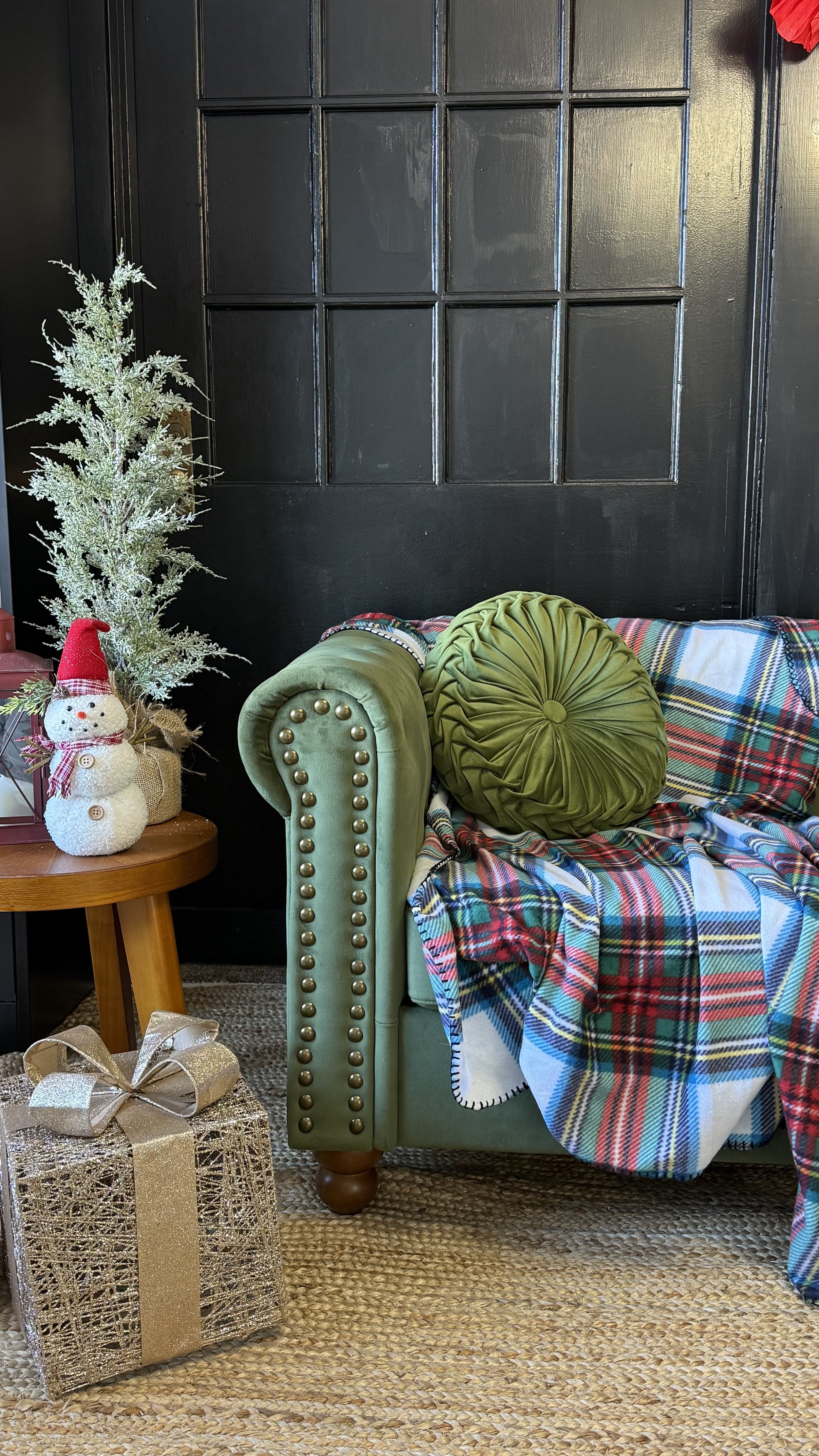 Holiday couch photography set with green velvet studded couch, gold presents, christmas theme accent tree, snowman and red lantern