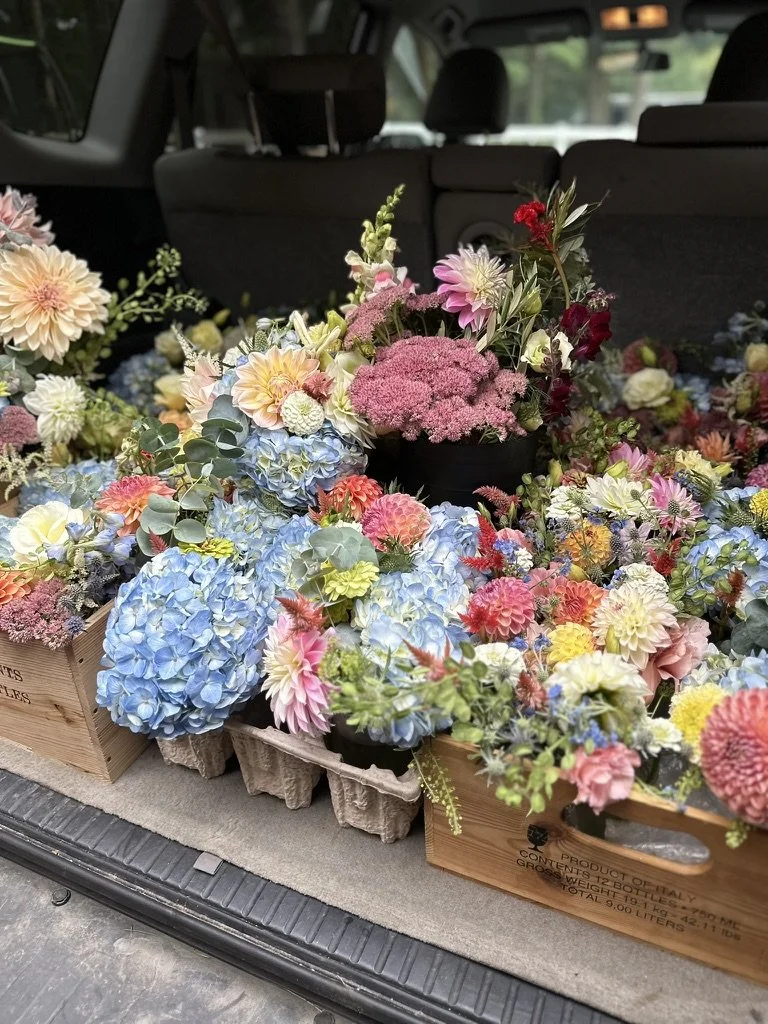 An SUV packed up with Wedding flowers in lush colorful arrangements