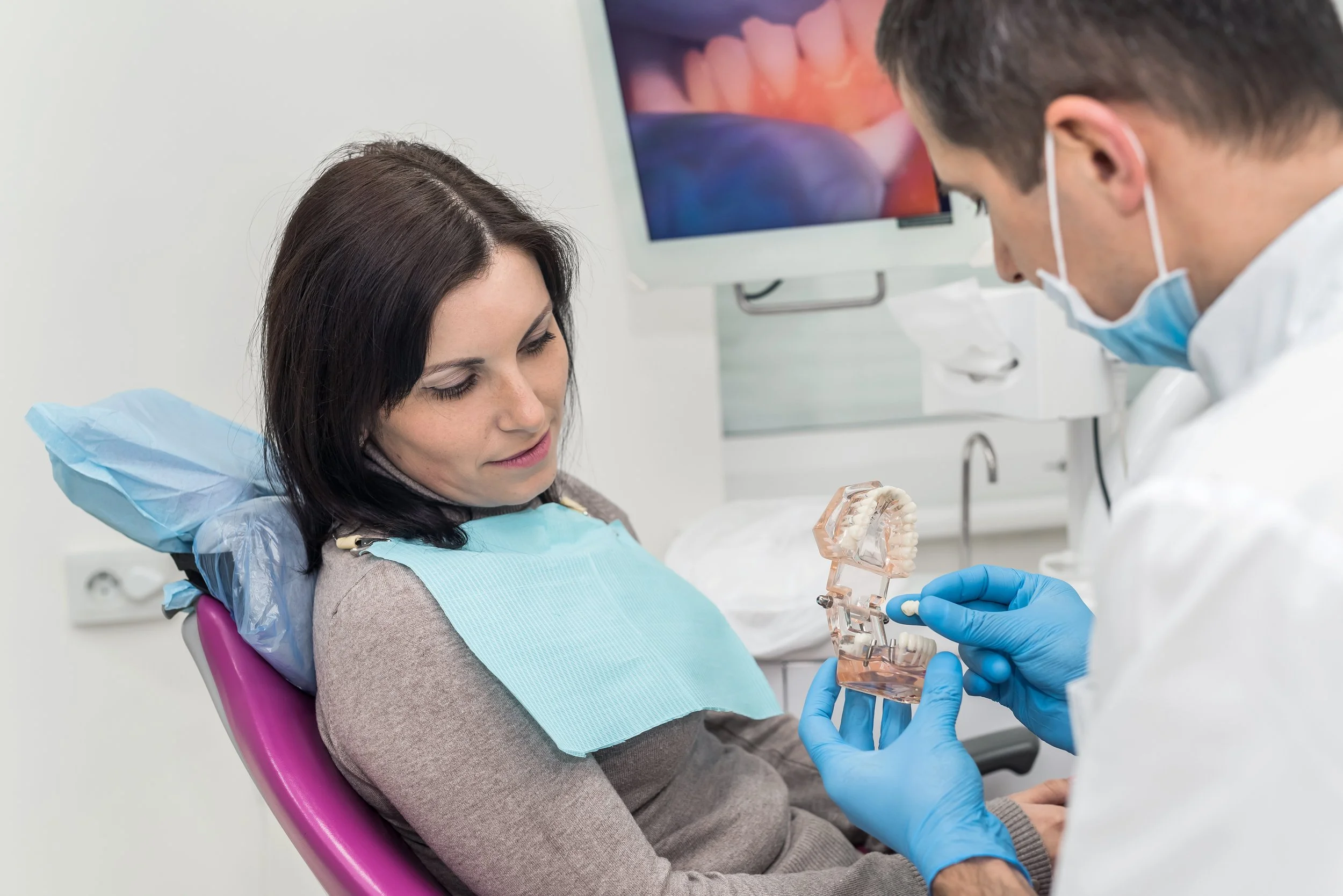 Woman in dentist chair with dentist and mold. Learn how CEREC same-day crown technology works, from digital scanning to in-office milling. Get a permanent crown in one visit at Kirkwood Family Dental.