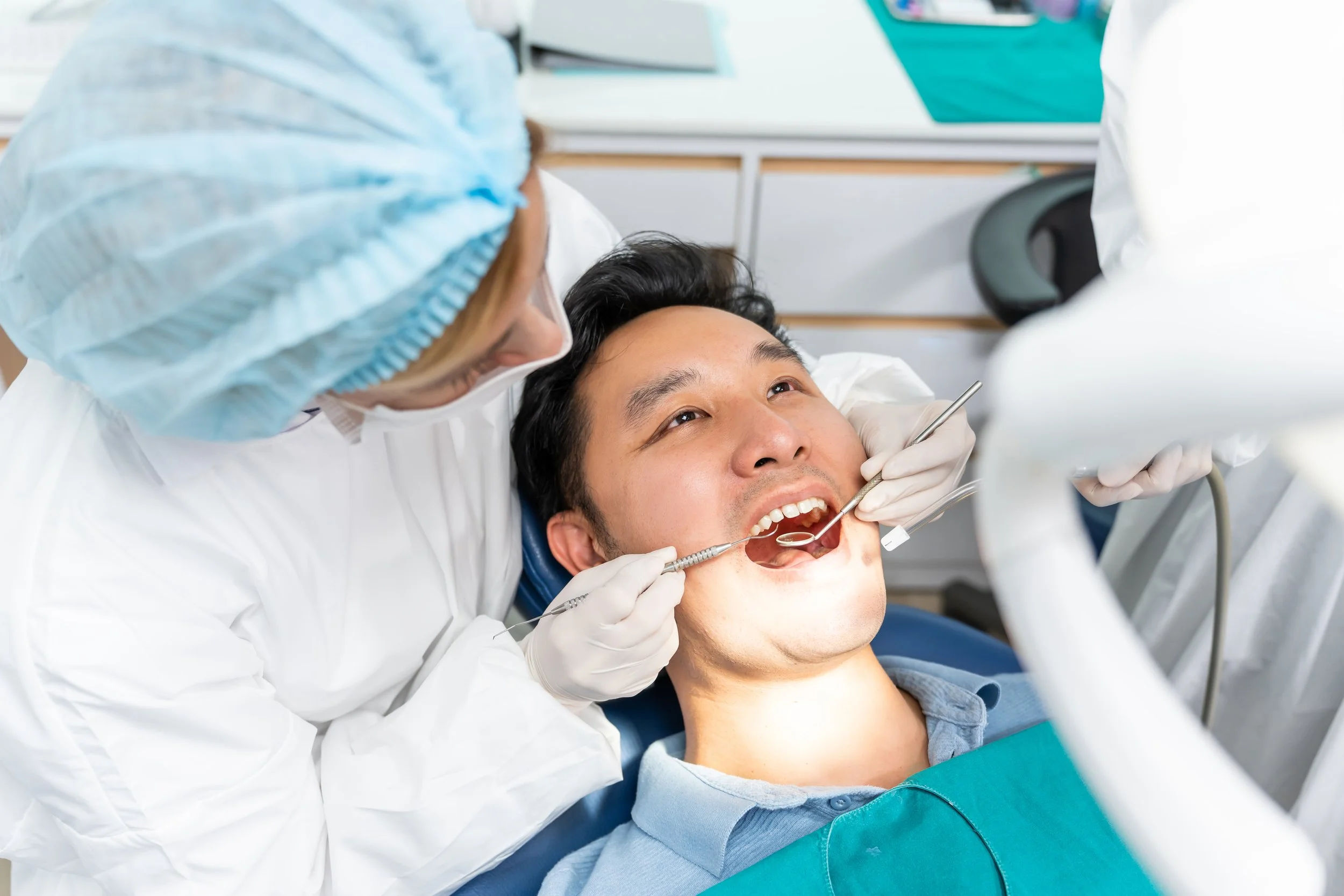 Man in dental chair. Tooth sensitive after a filling? Learn what's normal, how long it lasts, and the warning signs that mean it's time to call your dentist,
