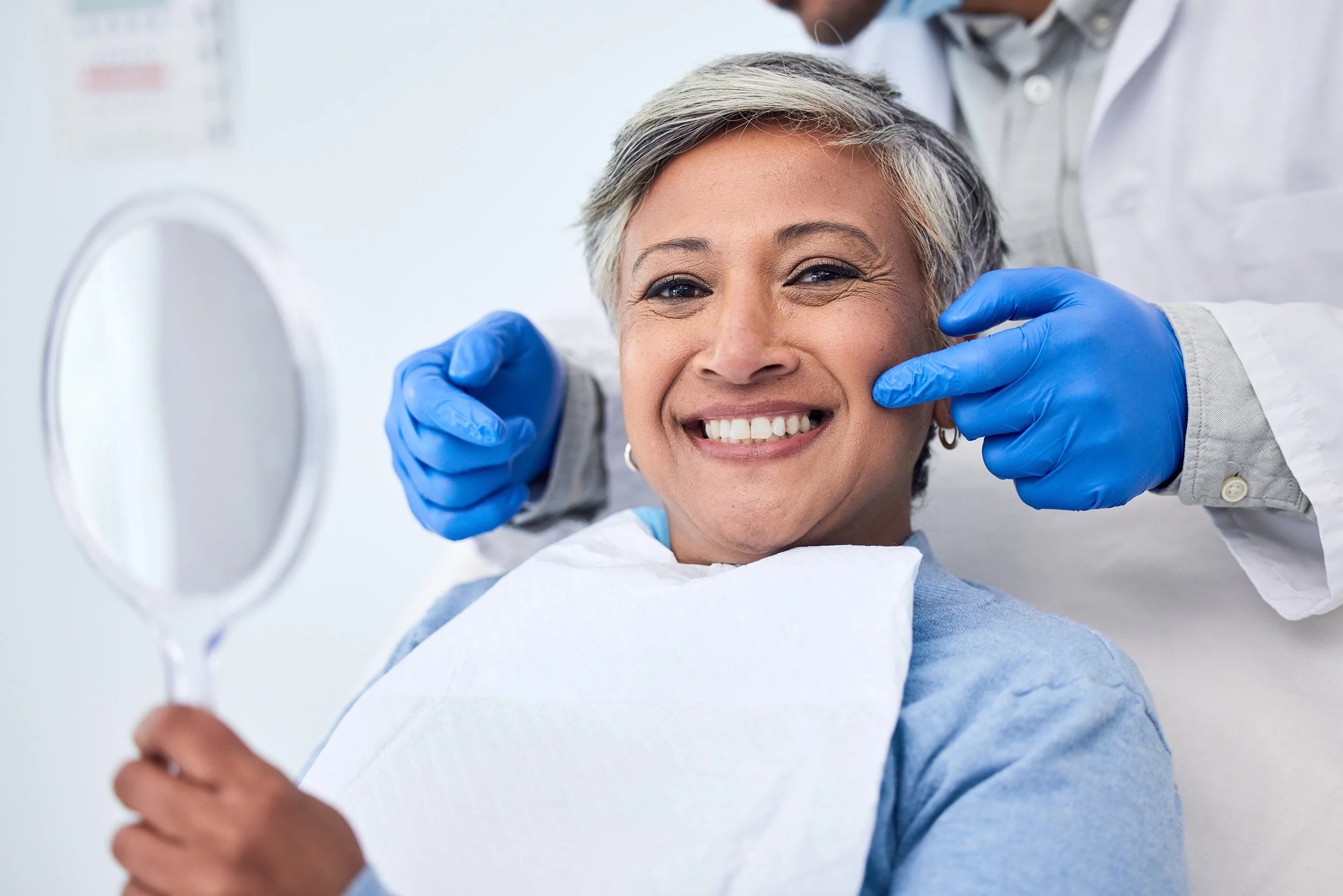 A woman smiles from the dental chair.