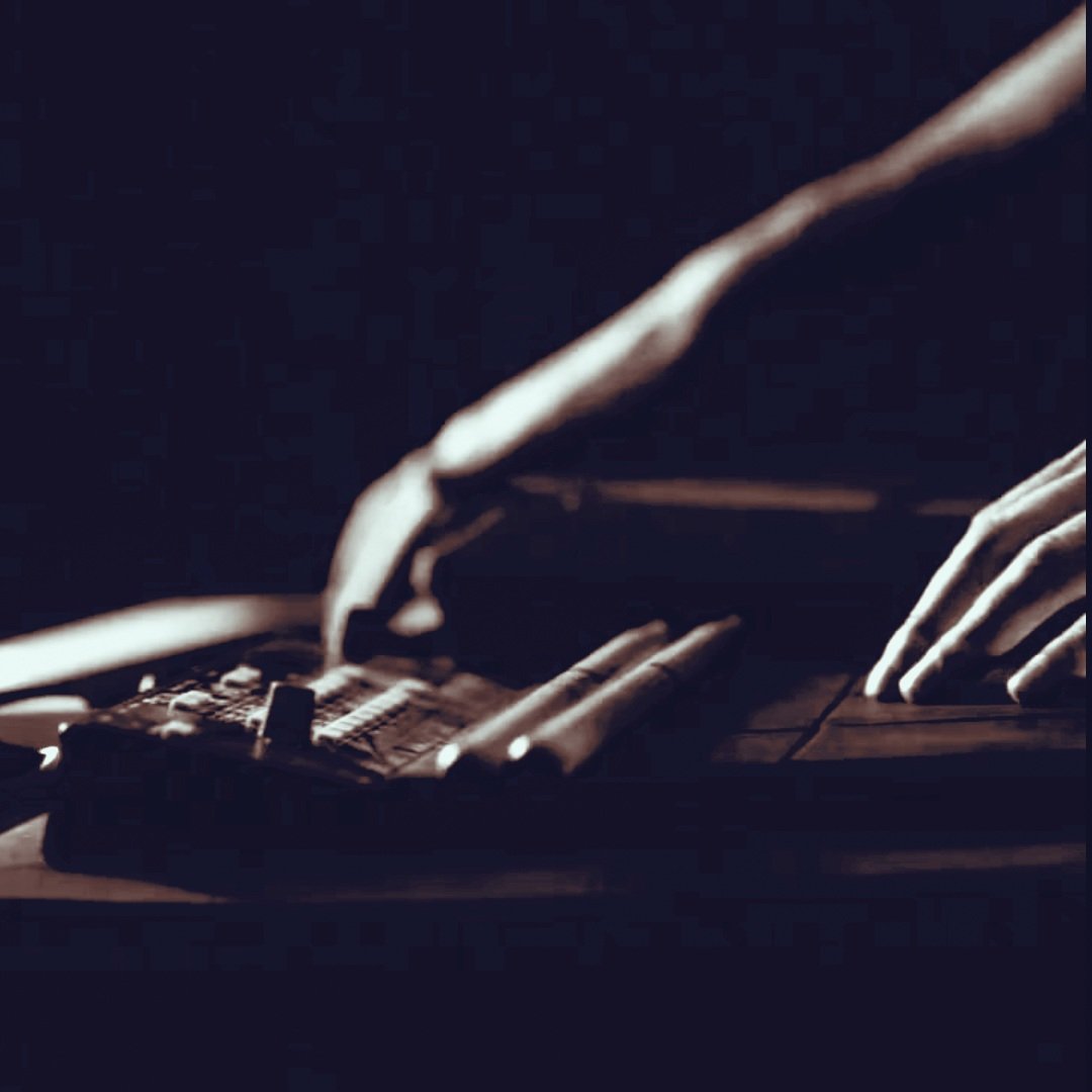 Nahaufnahme von einer Person, die eine elektrische Gitarre spielt, bei schwachem Licht.