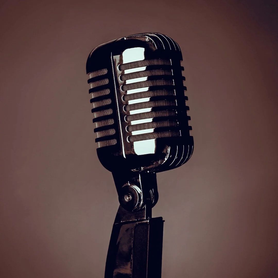 Altertümliches Schwarz-Weiß-Mikrofon auf dunklem Hintergrund.