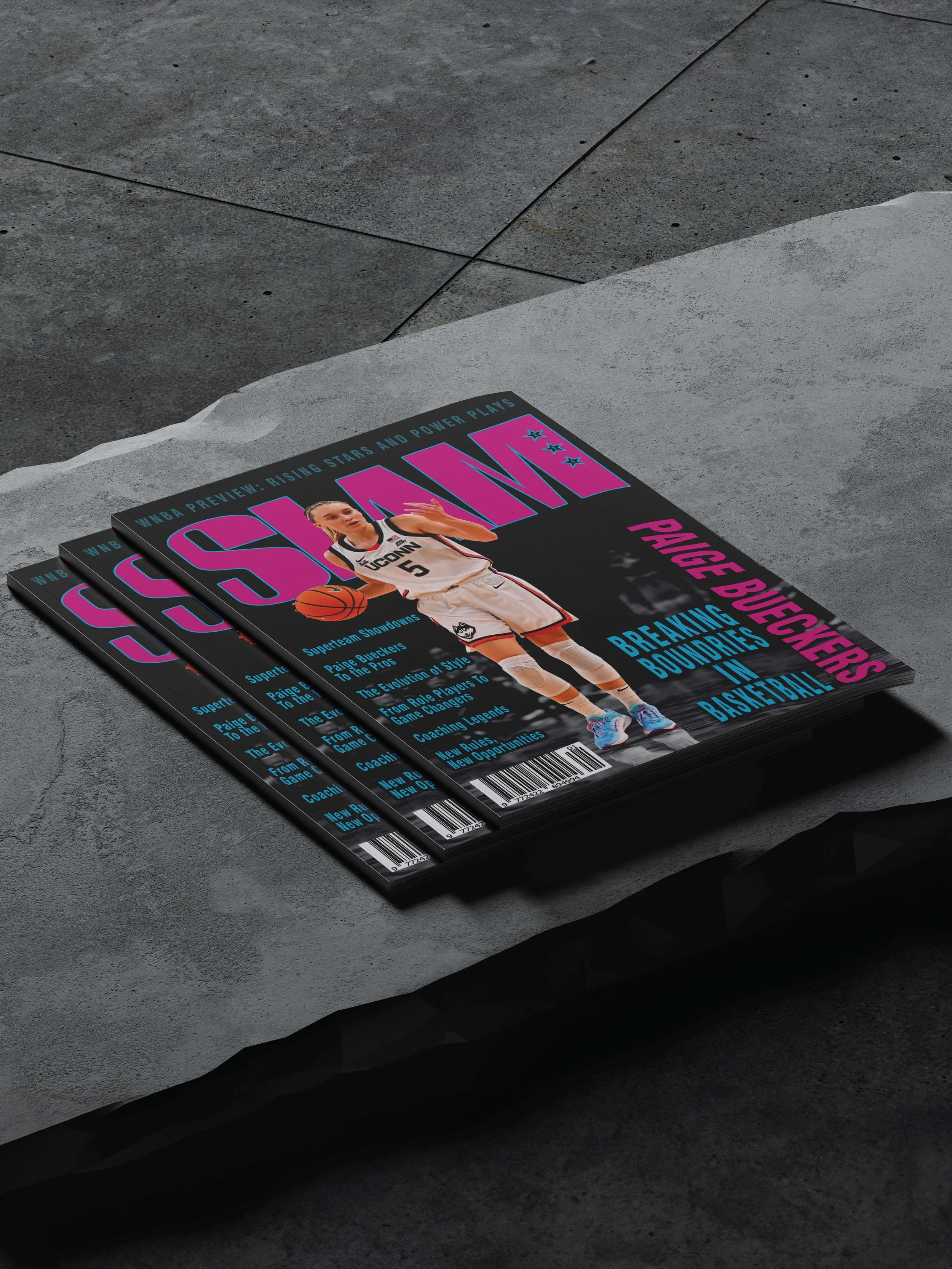 Three copies of a basketball magazine placed on a gray concrete surface, featuring a female player in a white uniform holding a basketball on the cover.