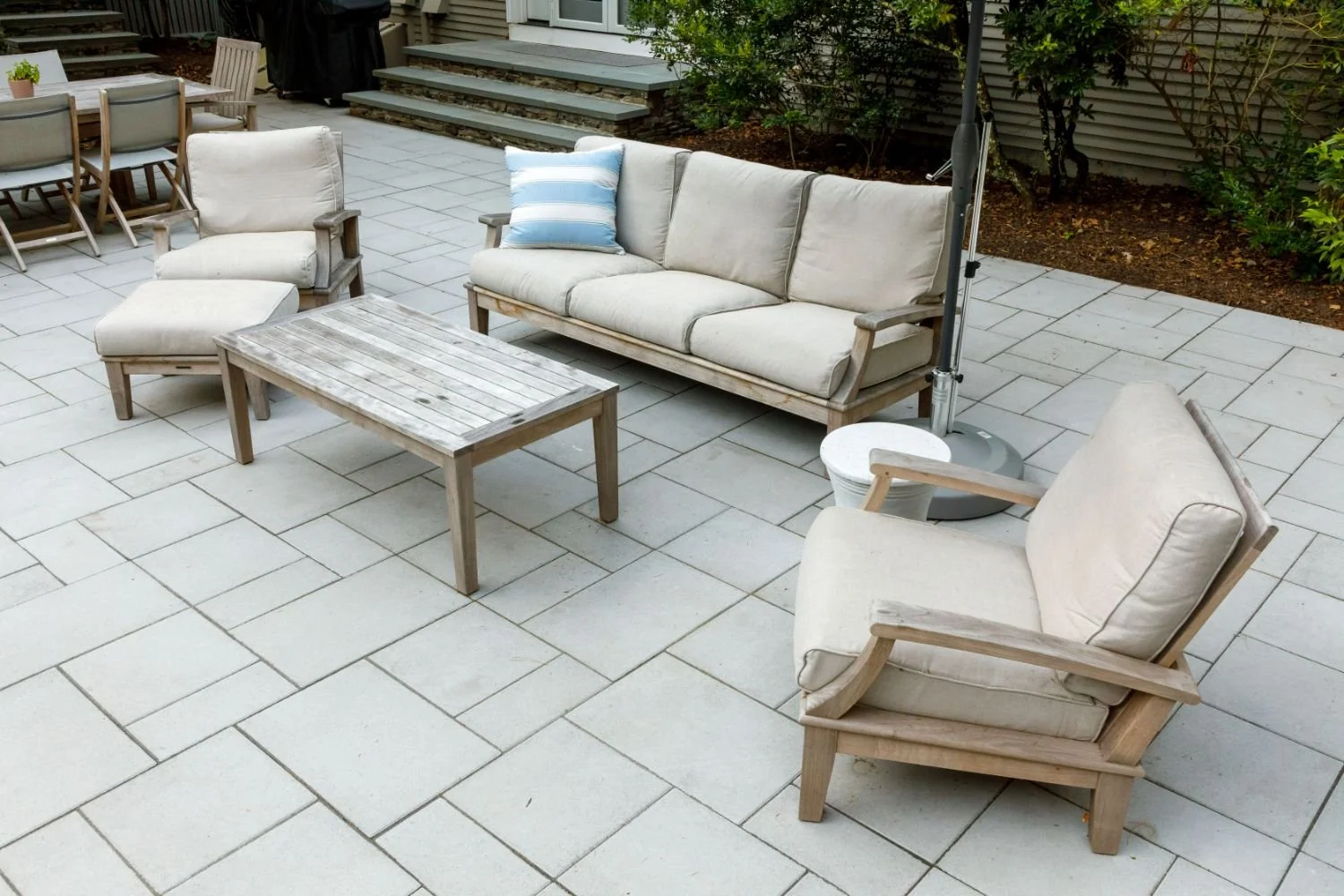 Stone patio extending from the home into the backyard landscape in Lexington, MA