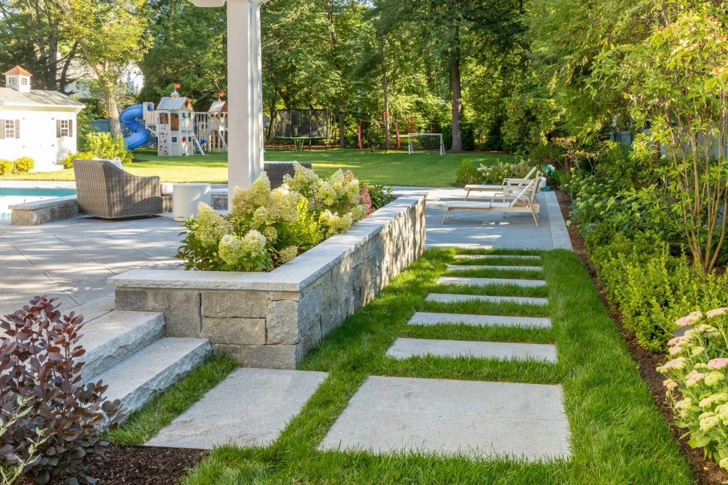 Garden path with large stone pavers set into lawn in Newton, MA